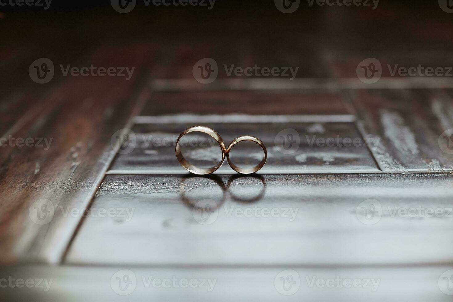 närbild av bröllop ringar i låda på tabell. bröllop ringar. två gyllene bröllop ringar i en trä- låda på en mjuk kudde. foto