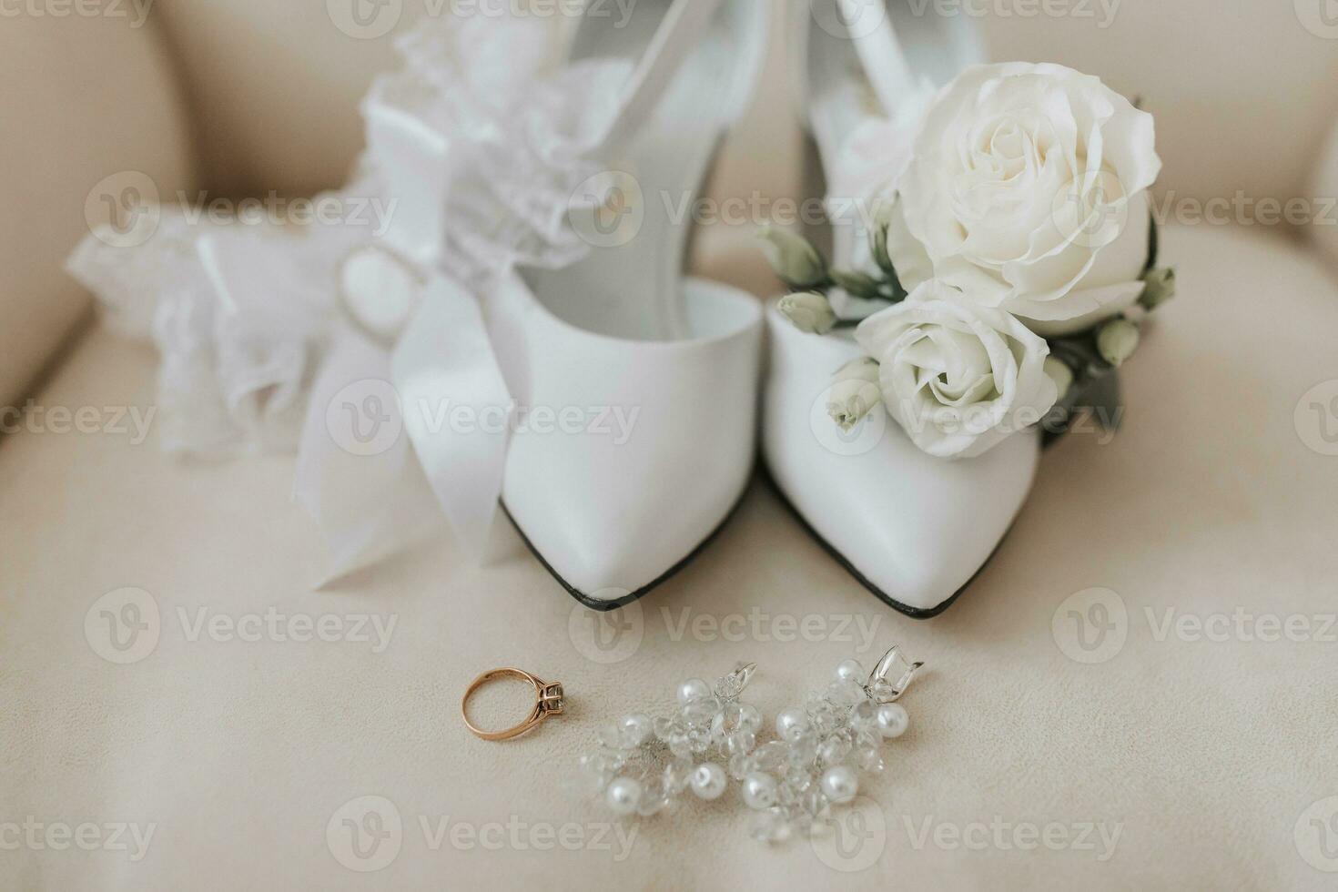 brud- Tillbehör i ljus färger, skor, örhängen, bröllop ringa, strumpeband och vrist stövlar foto