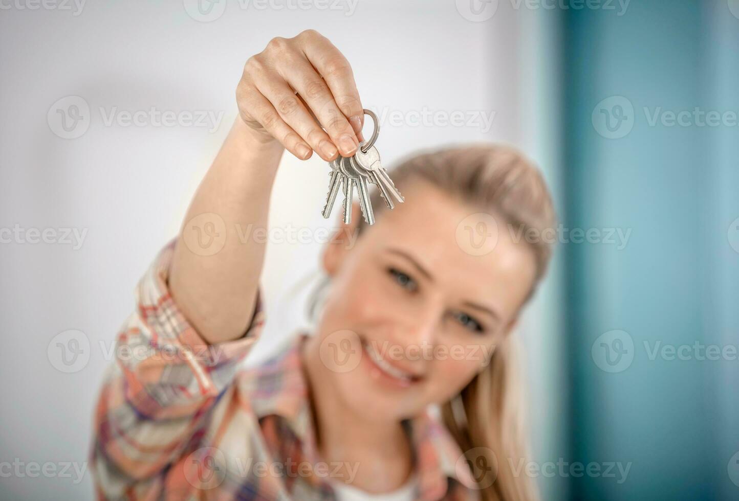 Lycklig kvinna med nycklar till en ny platt foto