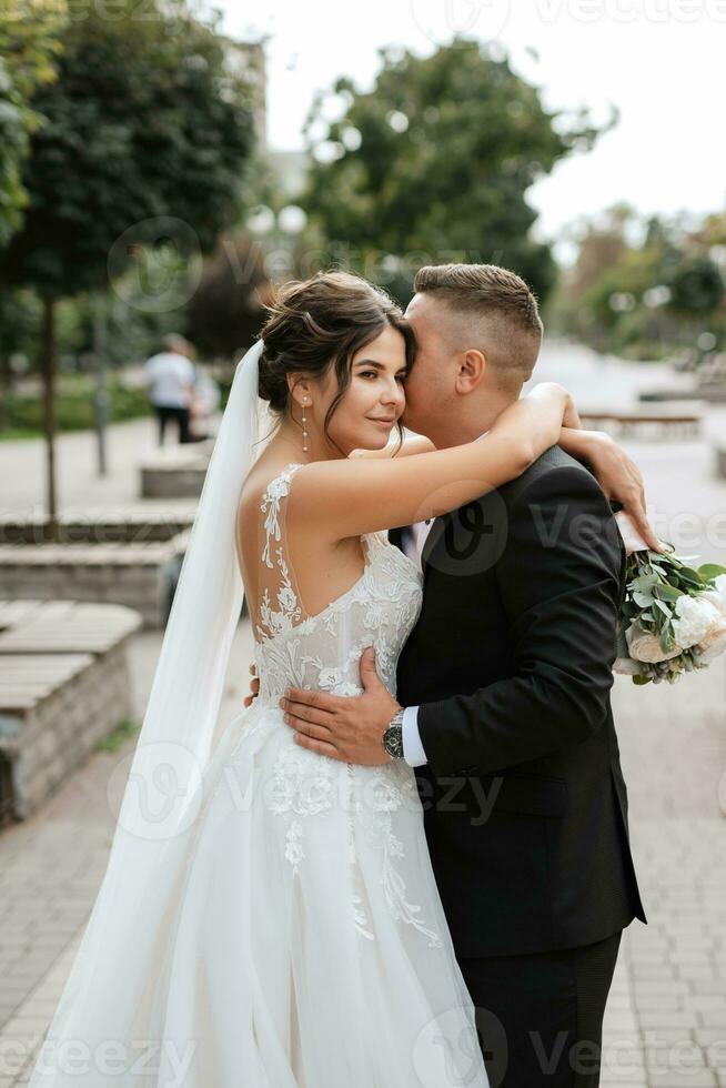 brudgummen i brun kostym och bruden i vit klänning foto