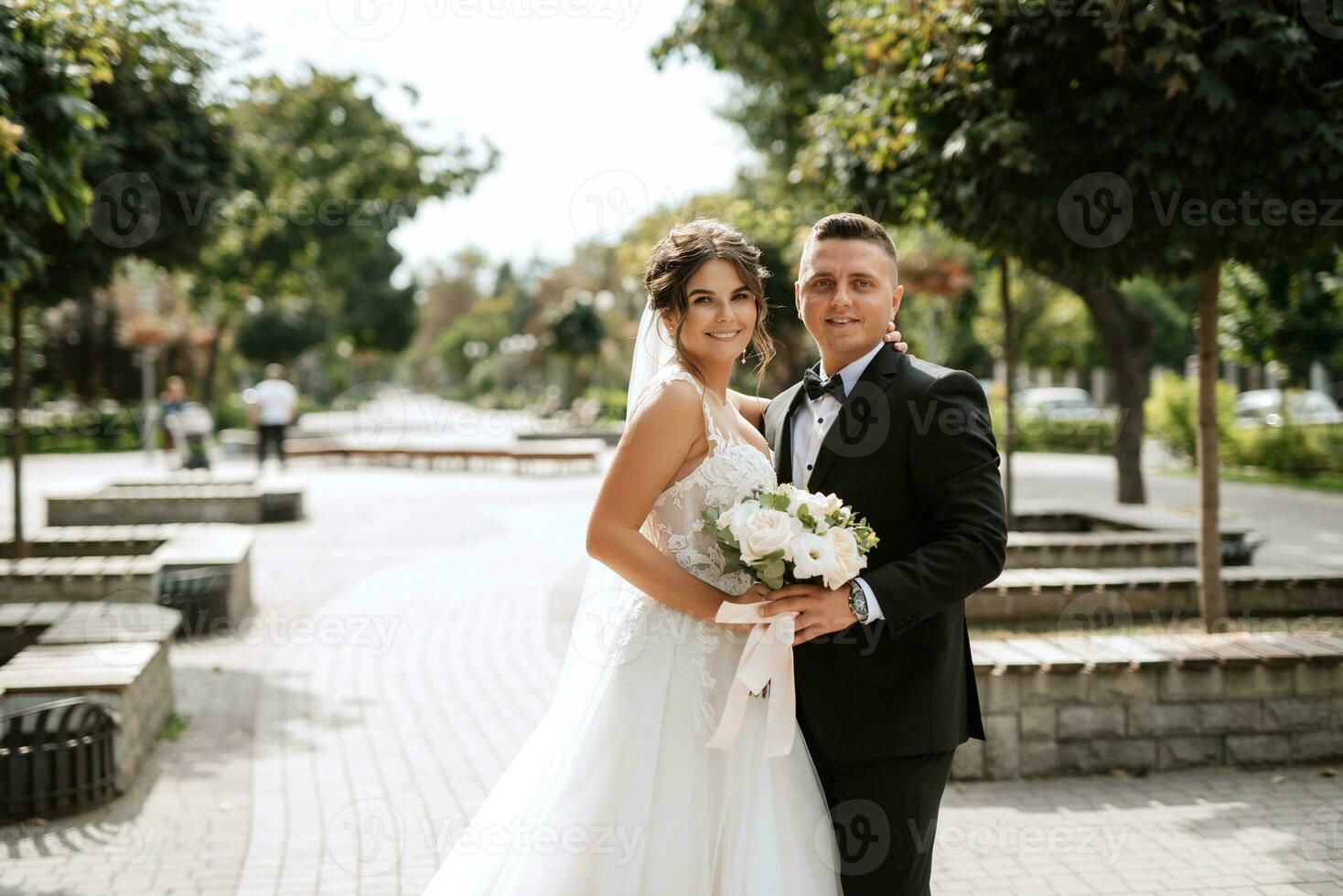 brudgummen i brun kostym och bruden i vit klänning foto