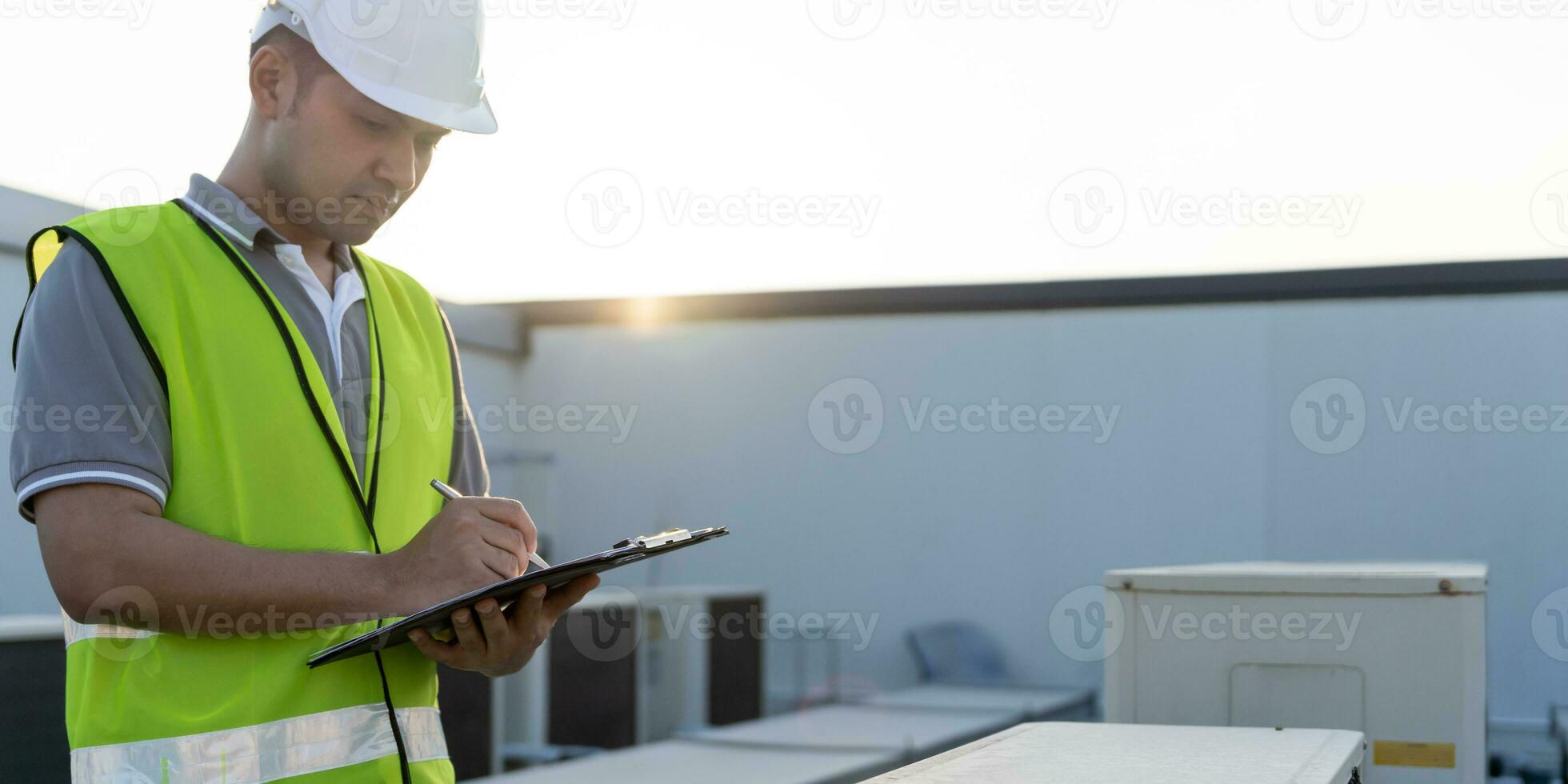 asiatisk underhåll ingenjör Arbetar på de tak av fabrik. entreprenör inspektera kompressor systemet och planer installation av luft tillstånd system i konstruktion. checklista, inspektör, kontrollera foto