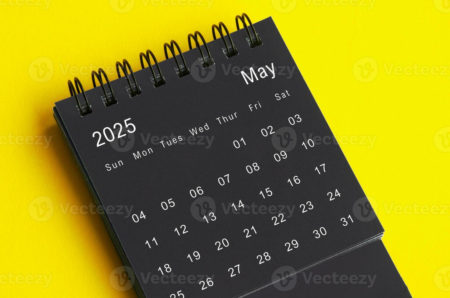 Maj 2025 svart och vit skrivbord kalender på gul omslag bakgrund. kalender begrepp foto