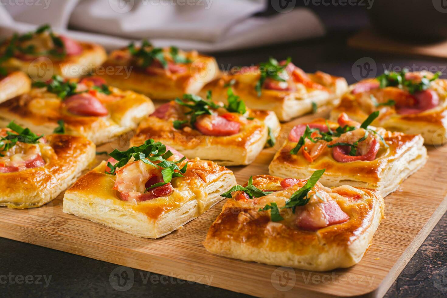 mini pizza med korvar, tomater, ost och örter på en trä- styrelse på de tabell foto