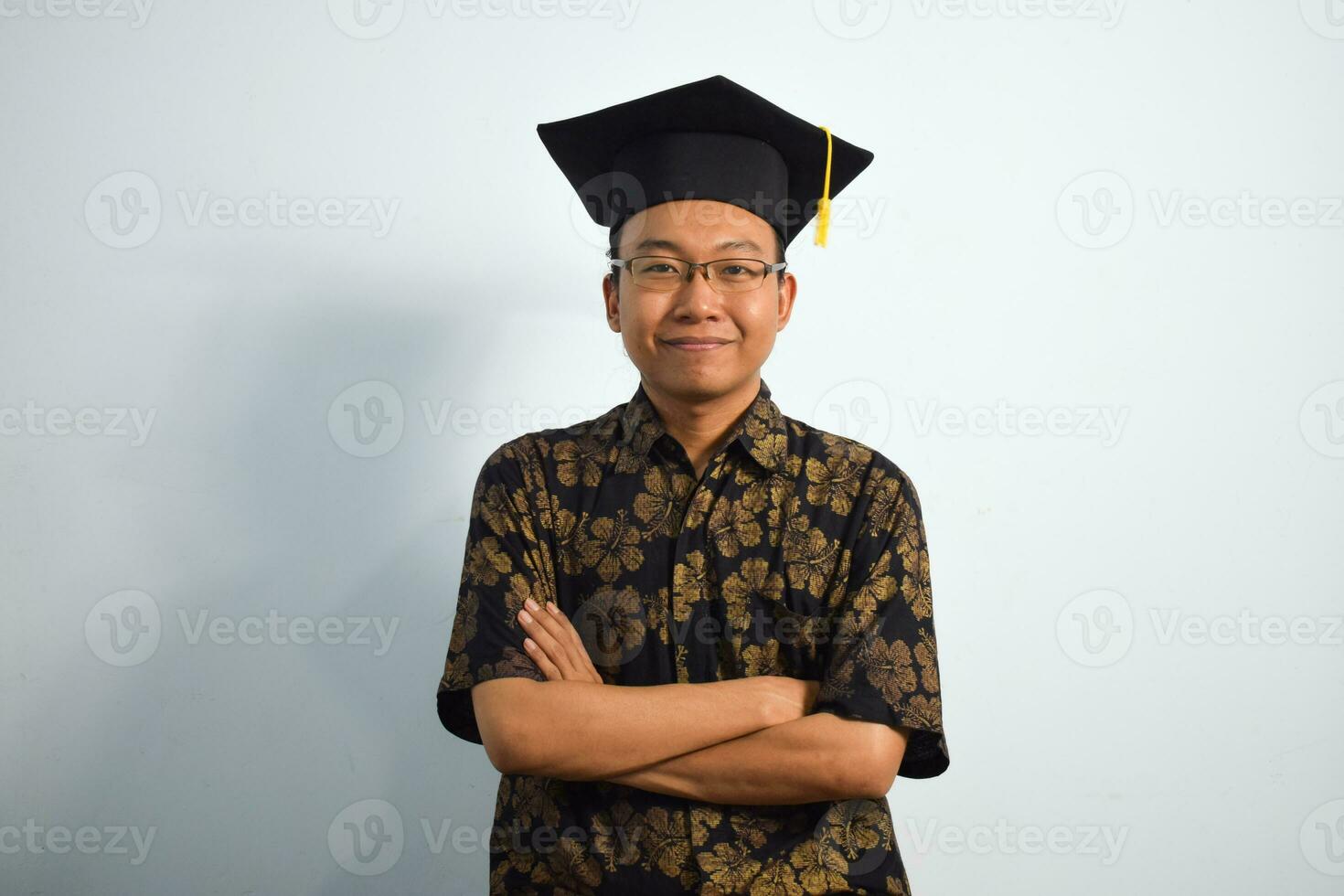 uttrycksfull av vuxen indonesien manlig ha på sig batik, toga kopp eller gradering hatt och glasögon isolerat på vit bakgrund, uttryck av porträtt gradering foto