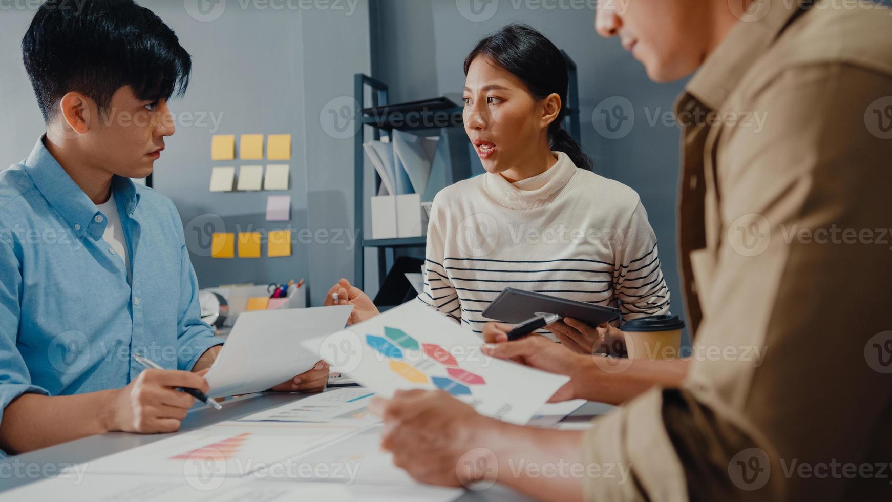 glada unga asiatiska affärsmän och affärskvinnor möter brainstorming några nya idéer om projekt till sin partner som arbetar tillsammans planerar framgångsstrategi njuter av lagarbete i små moderna hemmakontor. foto