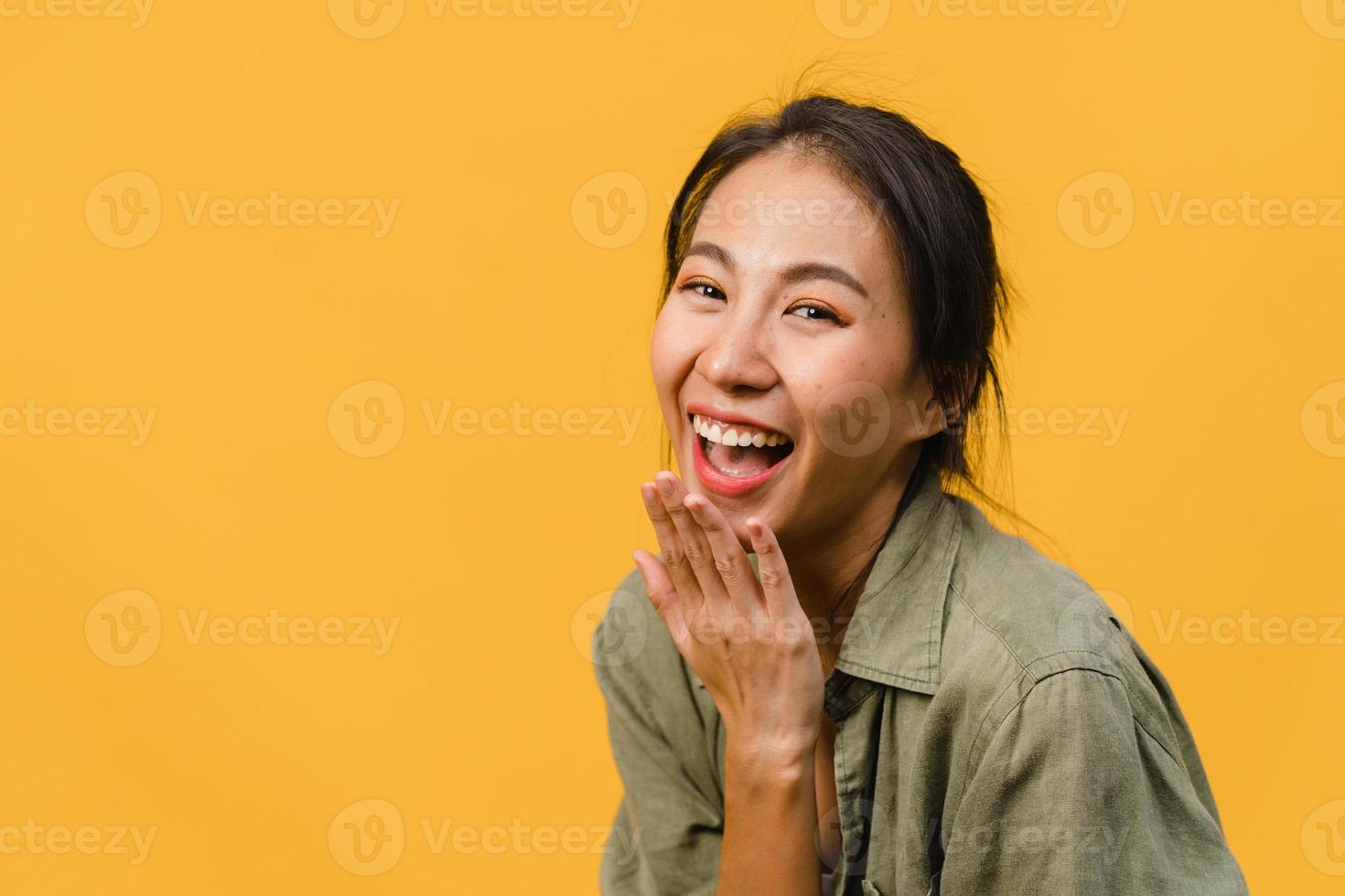 ung asiatisk dam med positivt uttryck, le brett, klädd i vardagskläder och titta på kameran över gul bakgrund. glad förtjusande glad kvinna jublar över framgång. ansiktsuttryck koncept. foto