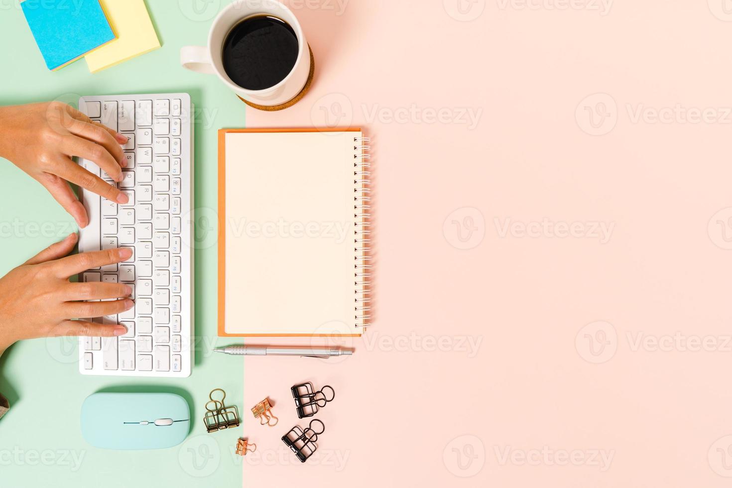 kreativt plattläggningsfoto av skrivbordet på arbetsytan. ovanifrån kontorsbord med tangentbord, mus och öppen mockup svart anteckningsbok på pastellgrön rosa färgbakgrund. ovanifrån håna med kopia utrymme fotografering. foto