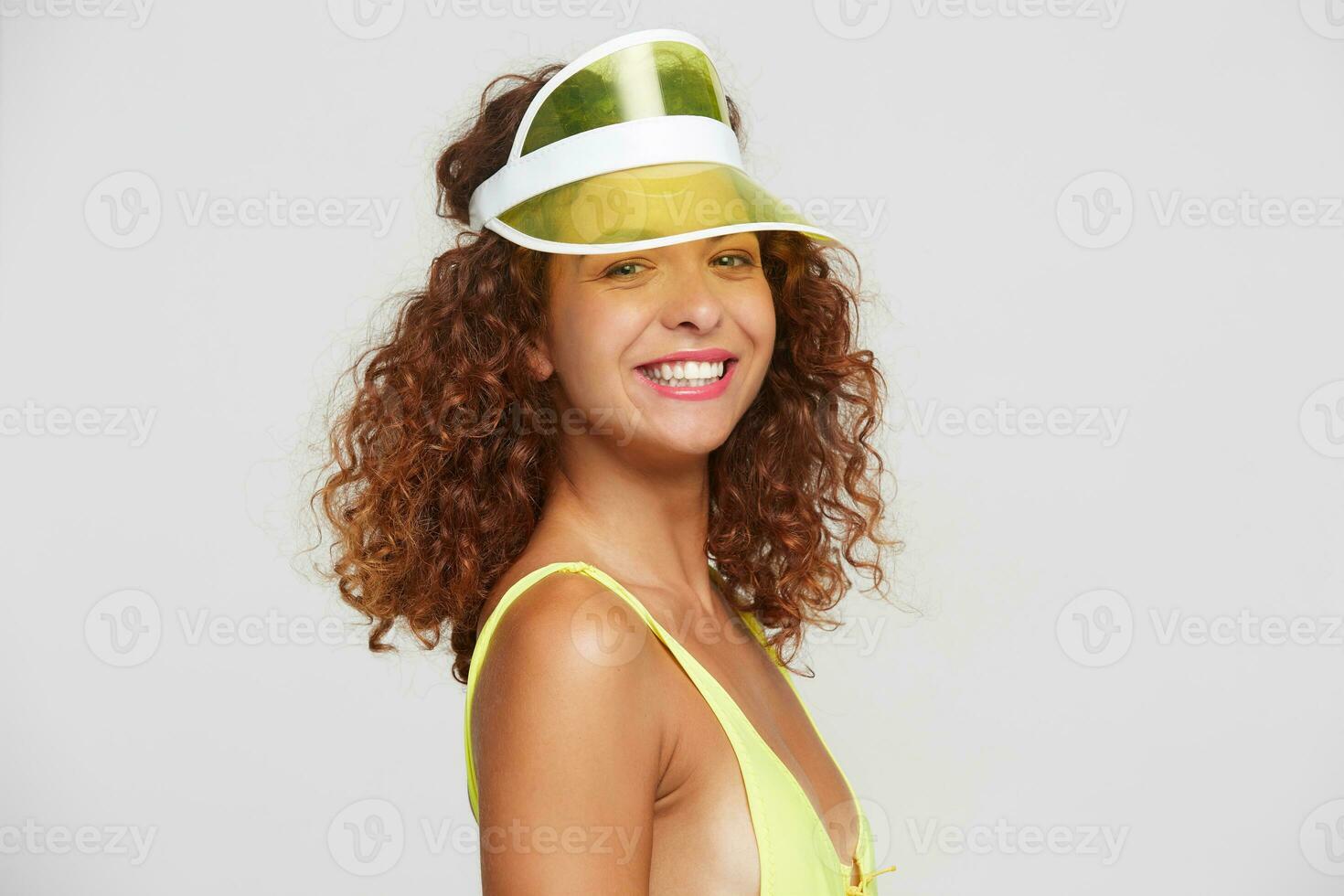 porträtt av ung härlig röd håriga lockigt kvinna med naturlig smink som visar henne vit perfekt tänder medan leende lyckligt på kamera, Framställ över vit bakgrund foto