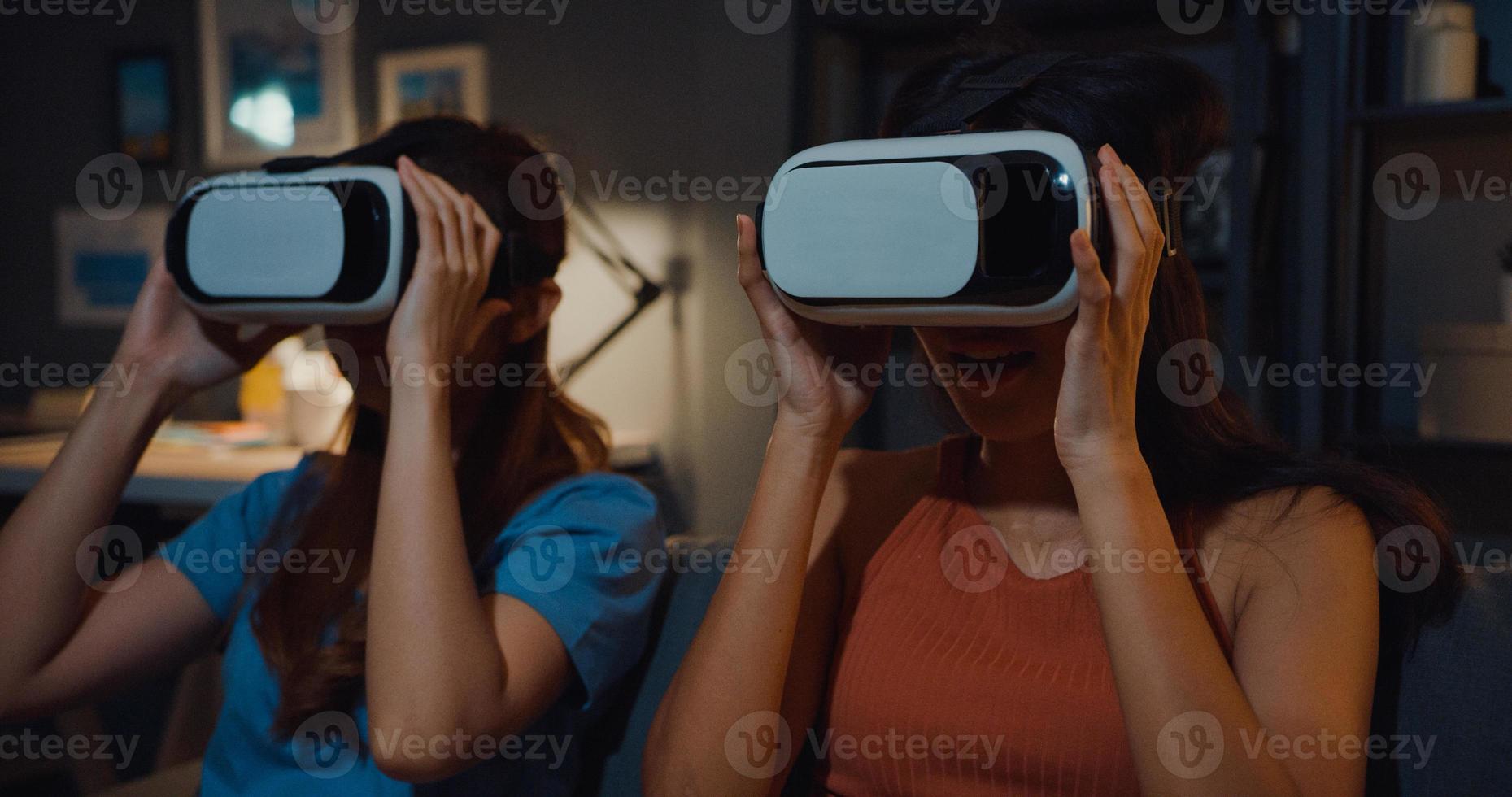 attraktiva asiatiska damer njuta av lyckligt ögonblick med att handla onlineupplevelse med virtual reality -glasögon headsetplats på soffan i hemmet vid mörk natt. använder med vr -glasögon headset för filmtid. foto