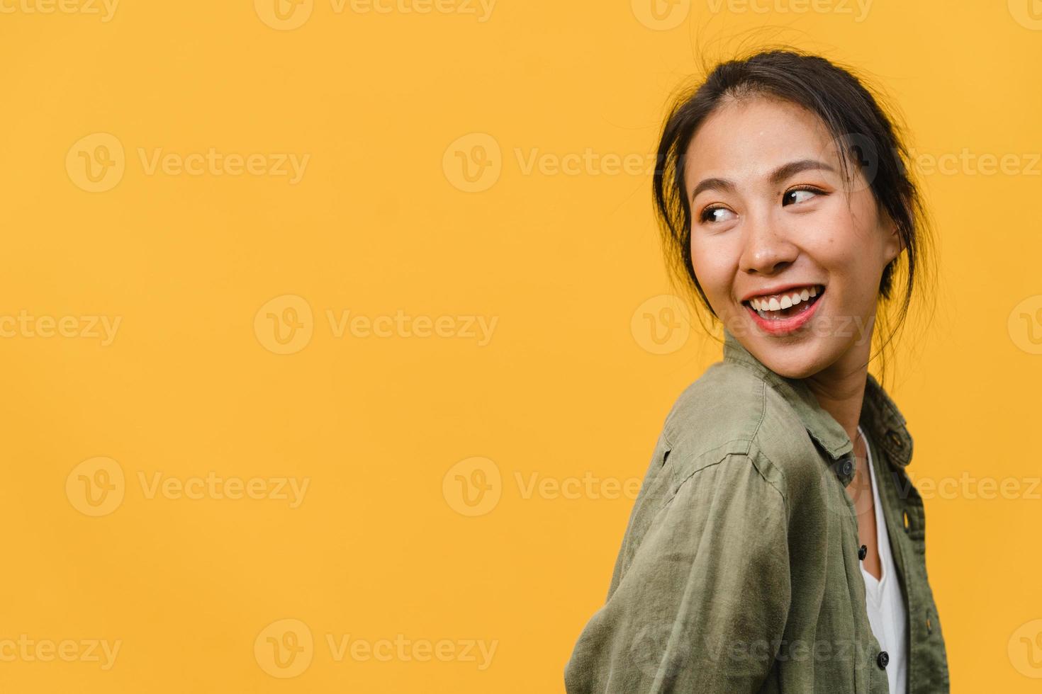 porträtt av ung asiatisk dam med positivt uttryck, le brett, klädd i vardagskläder över gul bakgrund. glad förtjusande glad kvinna jublar över framgång. ansiktsuttryck koncept. foto