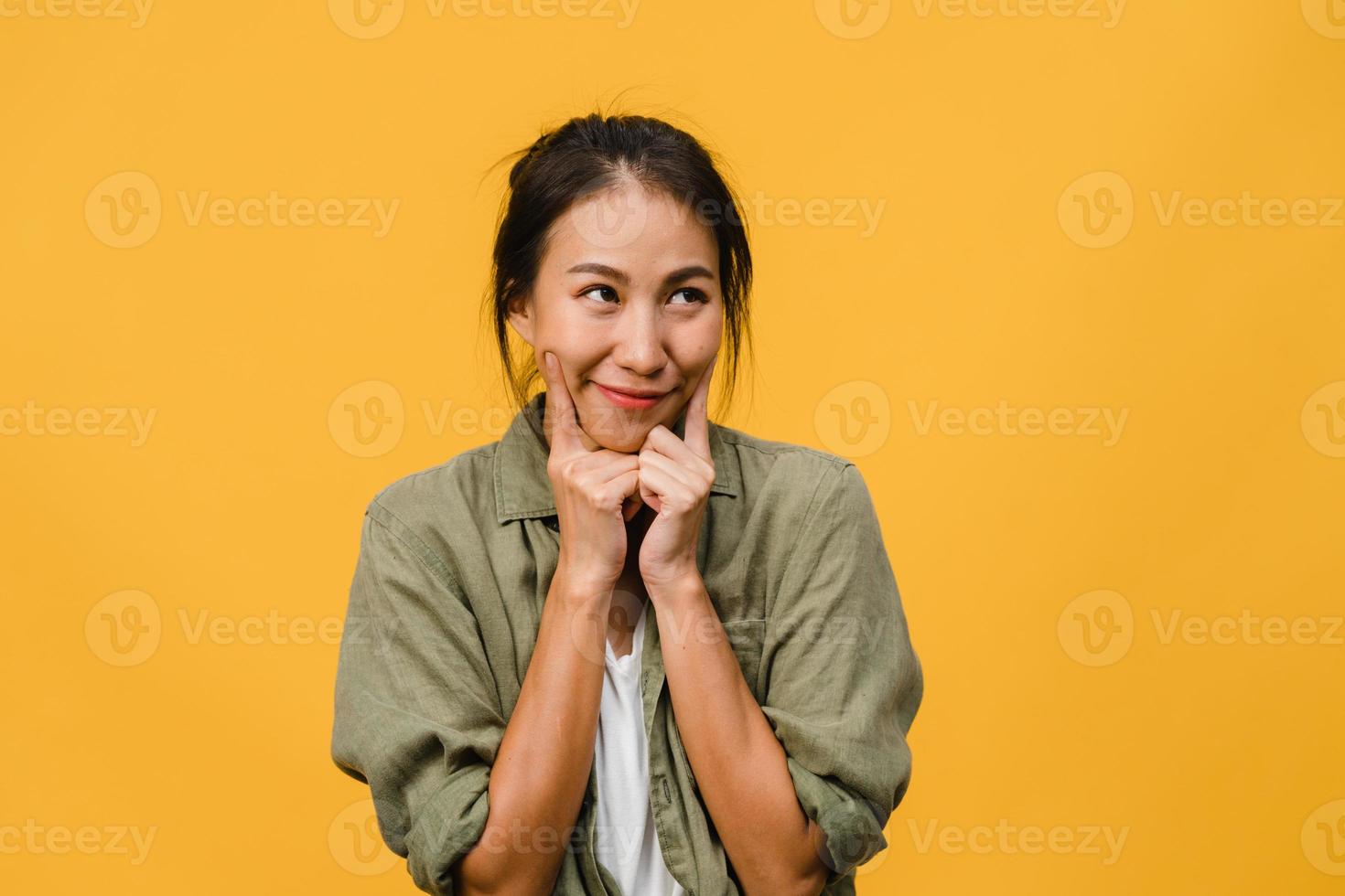 porträtt av ung asiatisk dam med positivt uttryck, le brett, klädd i vardagskläder över gul bakgrund. glad förtjusande glad kvinna jublar över framgång. ansiktsuttryck koncept. foto