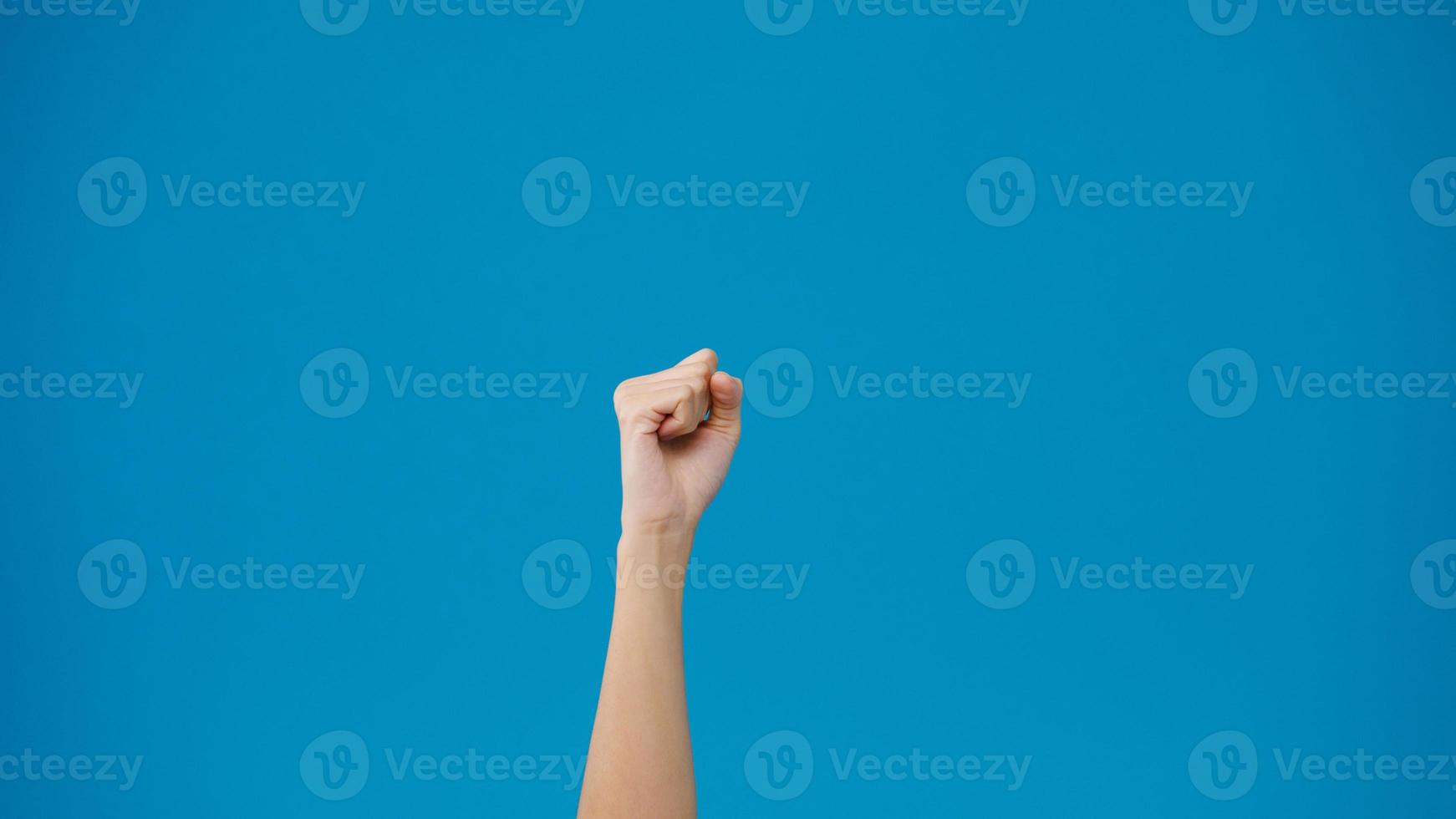 ung kvinna som visar handen palm knuten näve och knacka isolerad över blå bakgrund i studion. kopiera utrymme för att placera en text, meddelande för annons. reklamområde, håna reklaminnehåll. foto