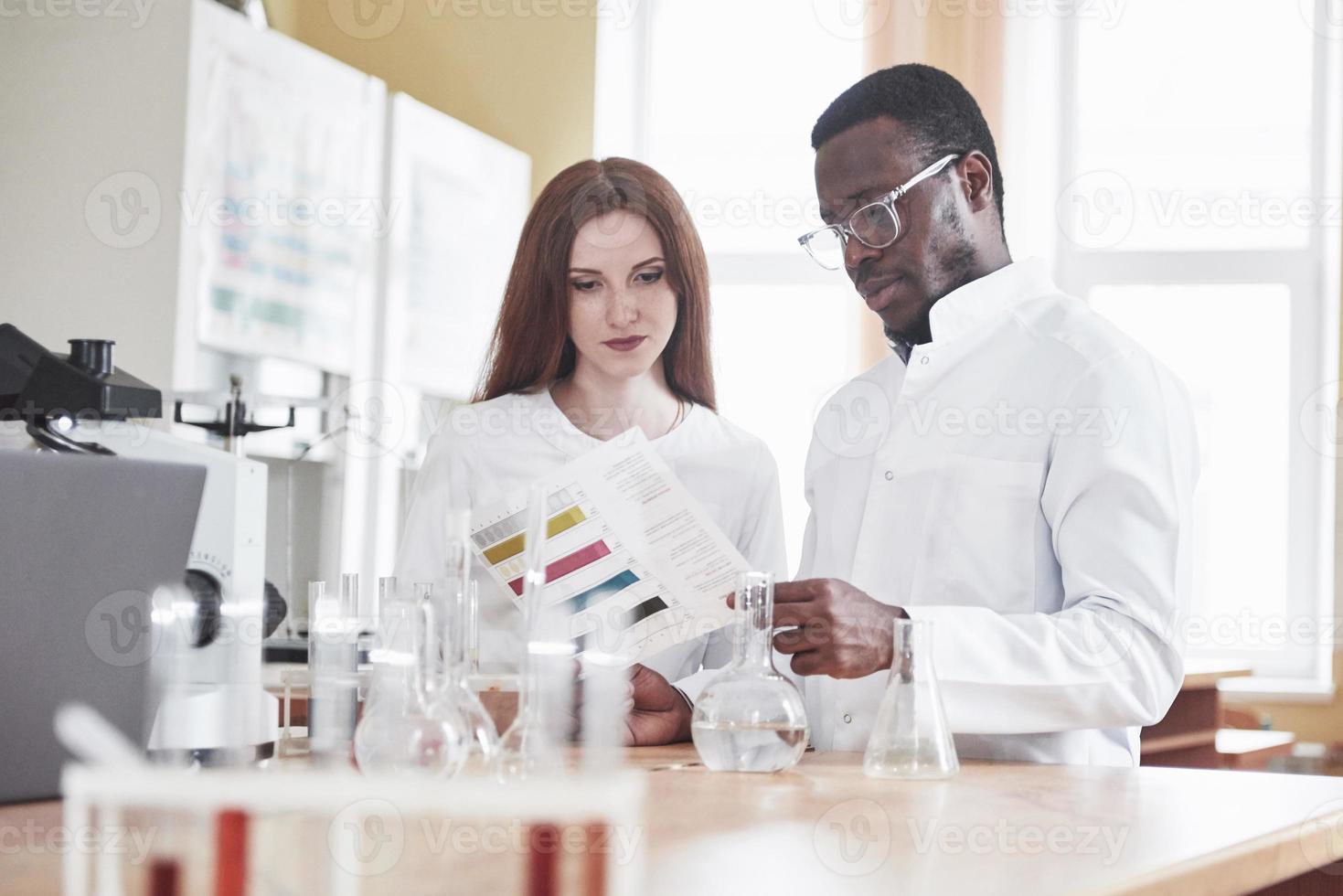 forskare arbetar nära med mikroskopet i laboratoriet genom att utföra experiment och analyser. foto