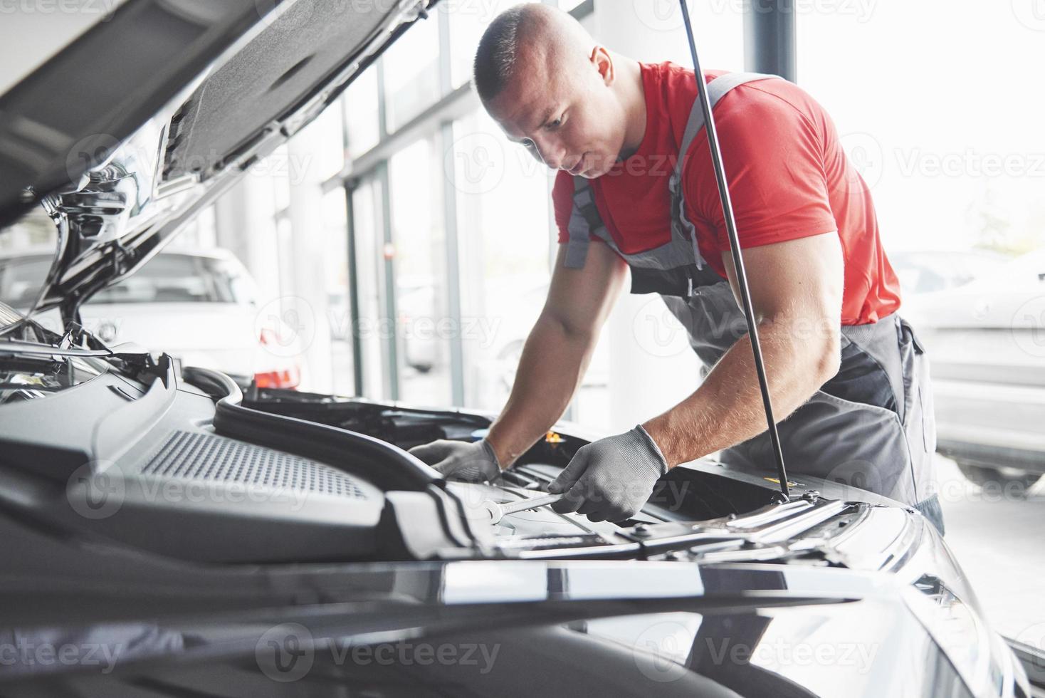 bild som visar muskulös bilservicearbetare som reparerar fordon foto