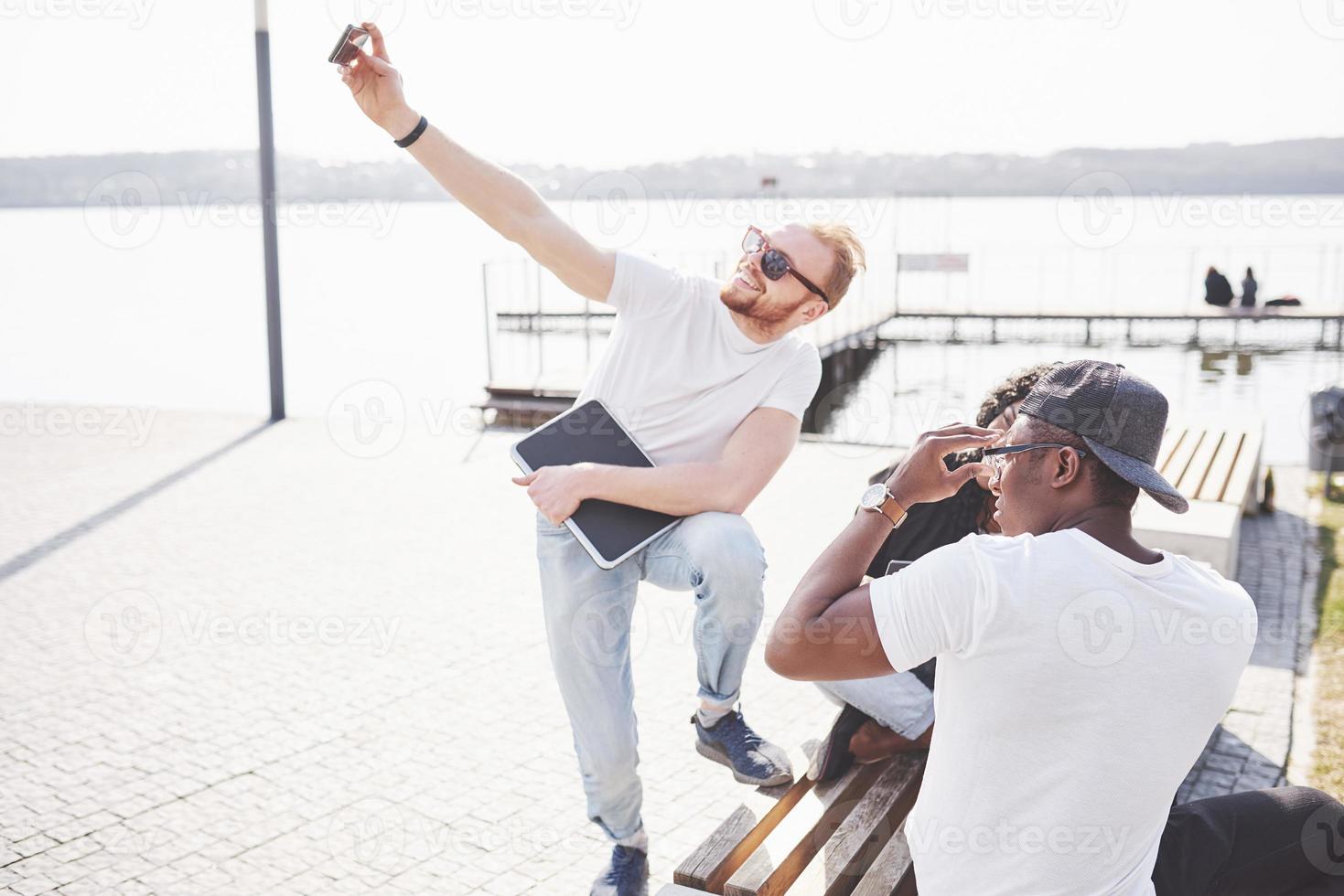 vackra multietniska vänner som använder en bärbar dator på gatan och gör selphie. ungdomens livsstilskoncept foto