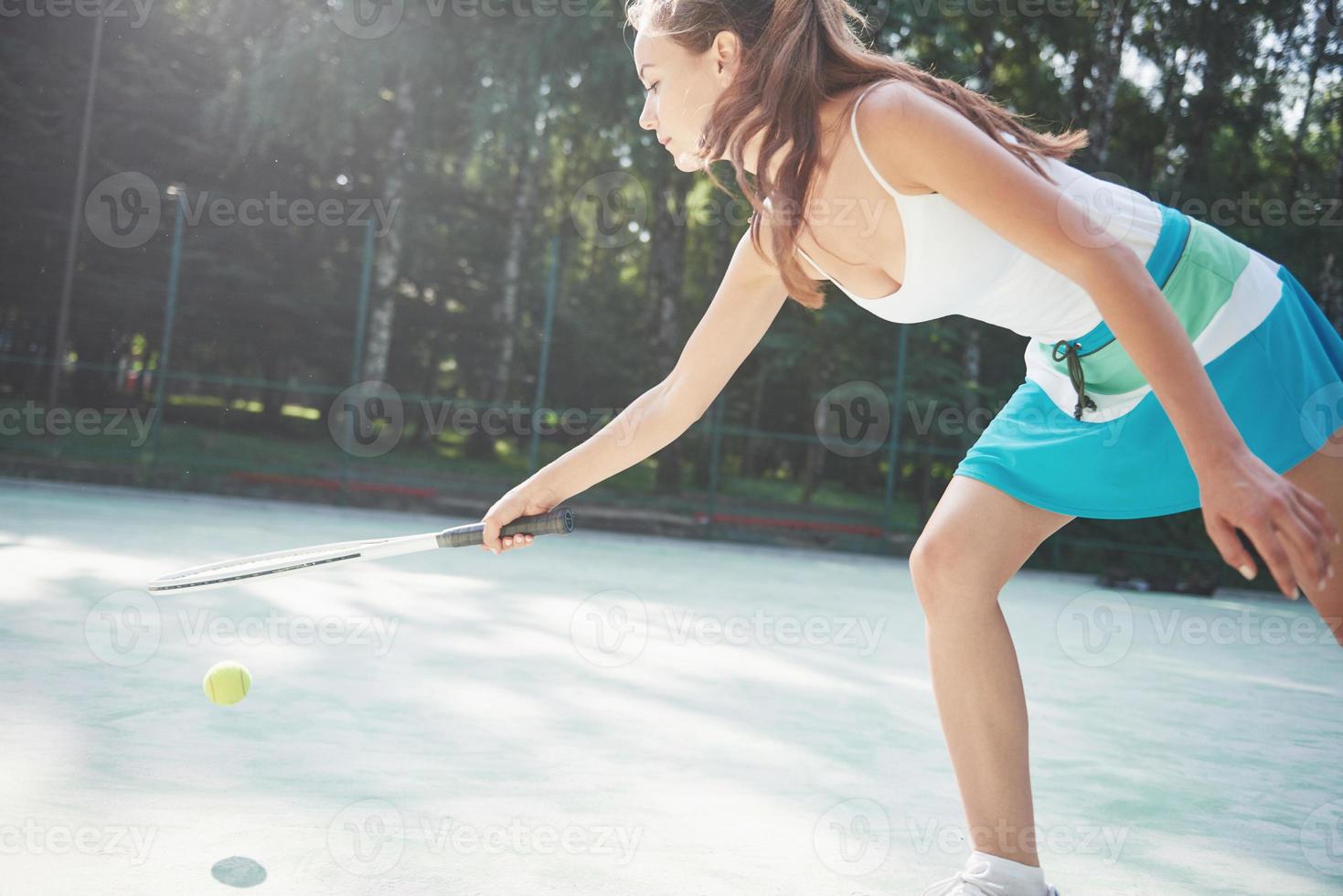 söt tjej som spelar tennis och poserar för kameran. foto