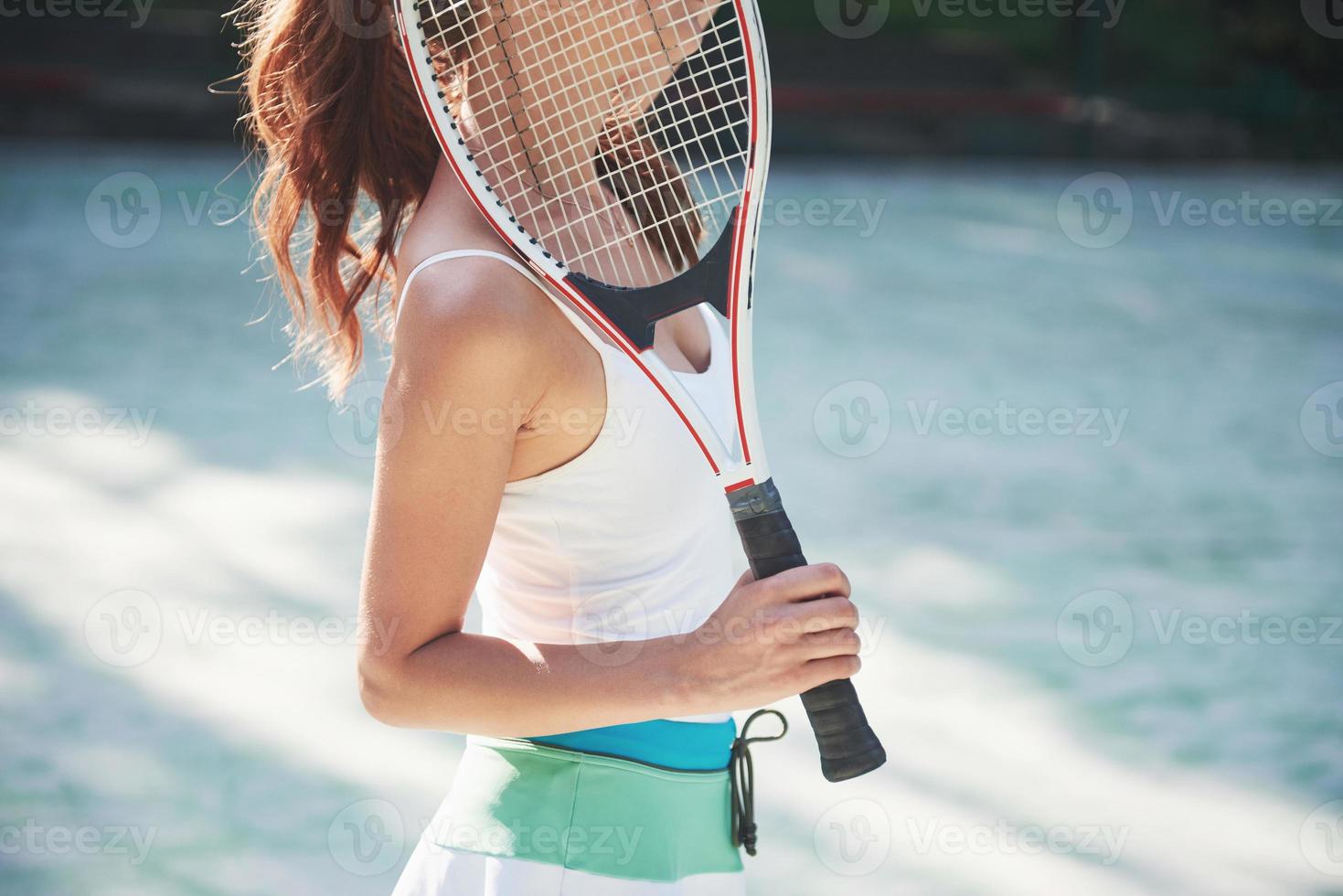 söt tjej som spelar tennis och poserar för kameran. foto