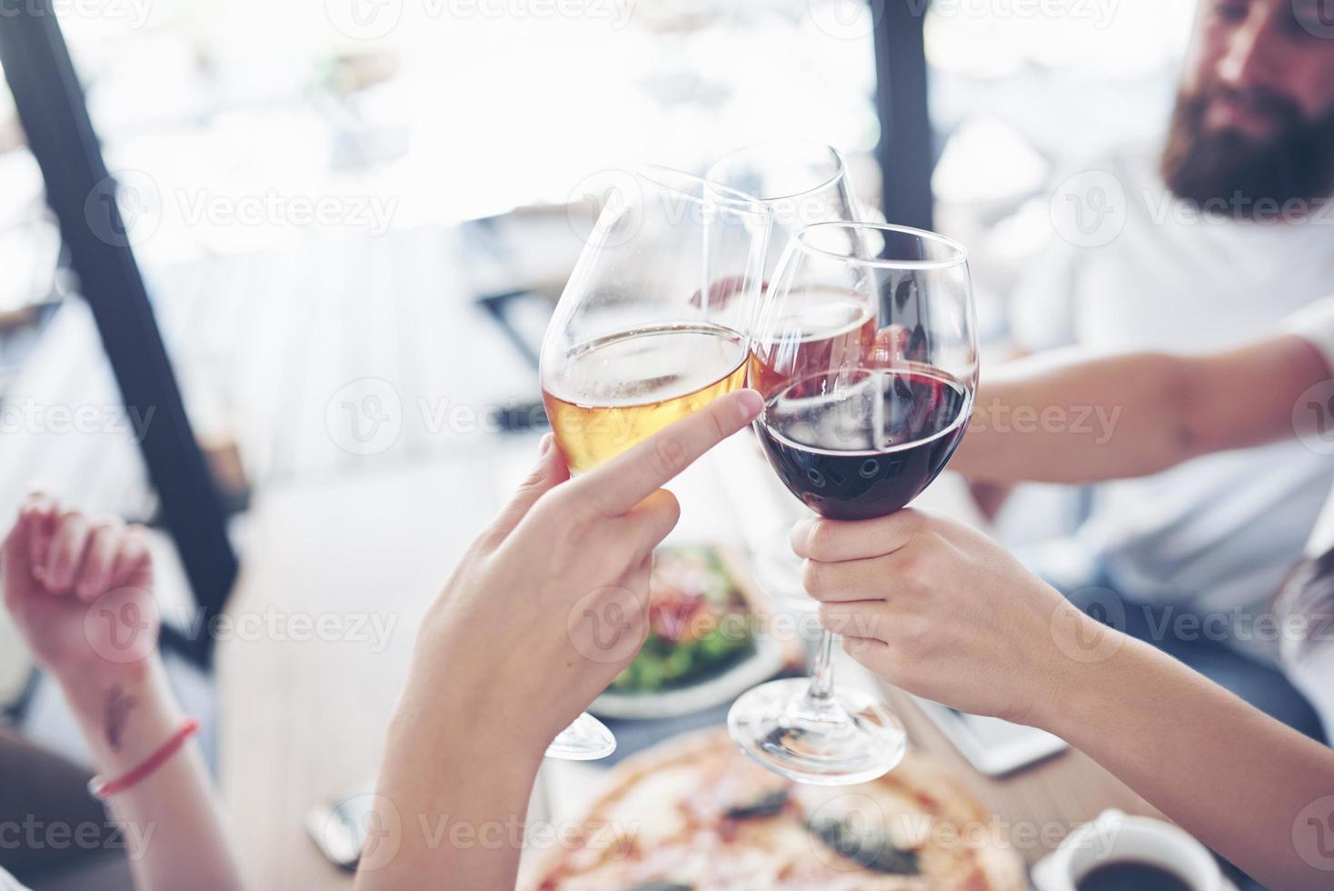 vänner samlades vid bordet med utsökt mat med glas rött vin för att fira ett speciellt tillfälle foto