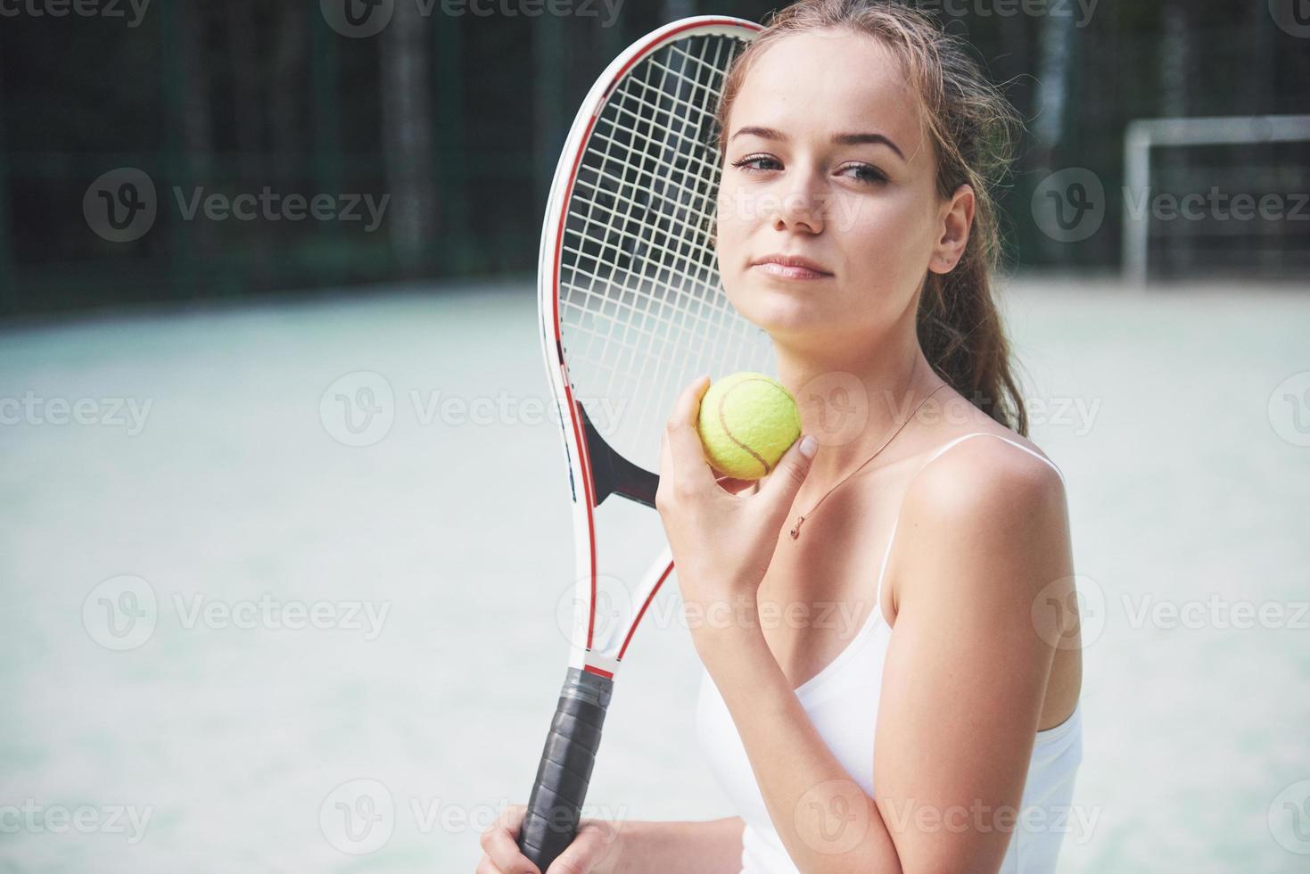 en vacker kvinna som bär en sportkläder tennisbana på banan foto