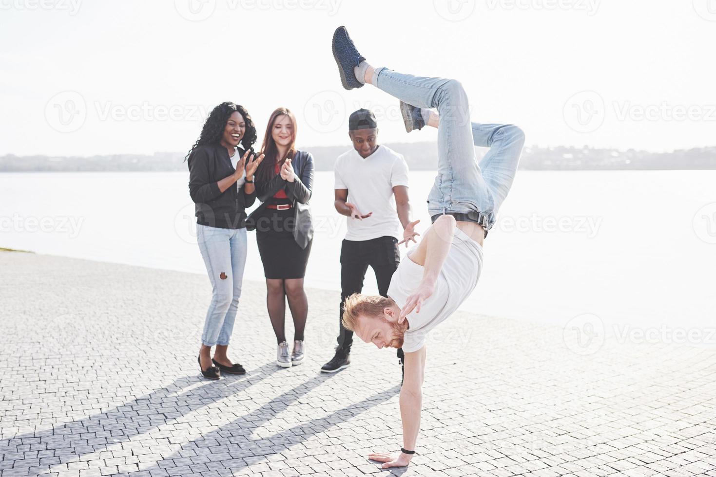 gatukonstnär breakdancing utomhus. överraskade vänner applåderar foto