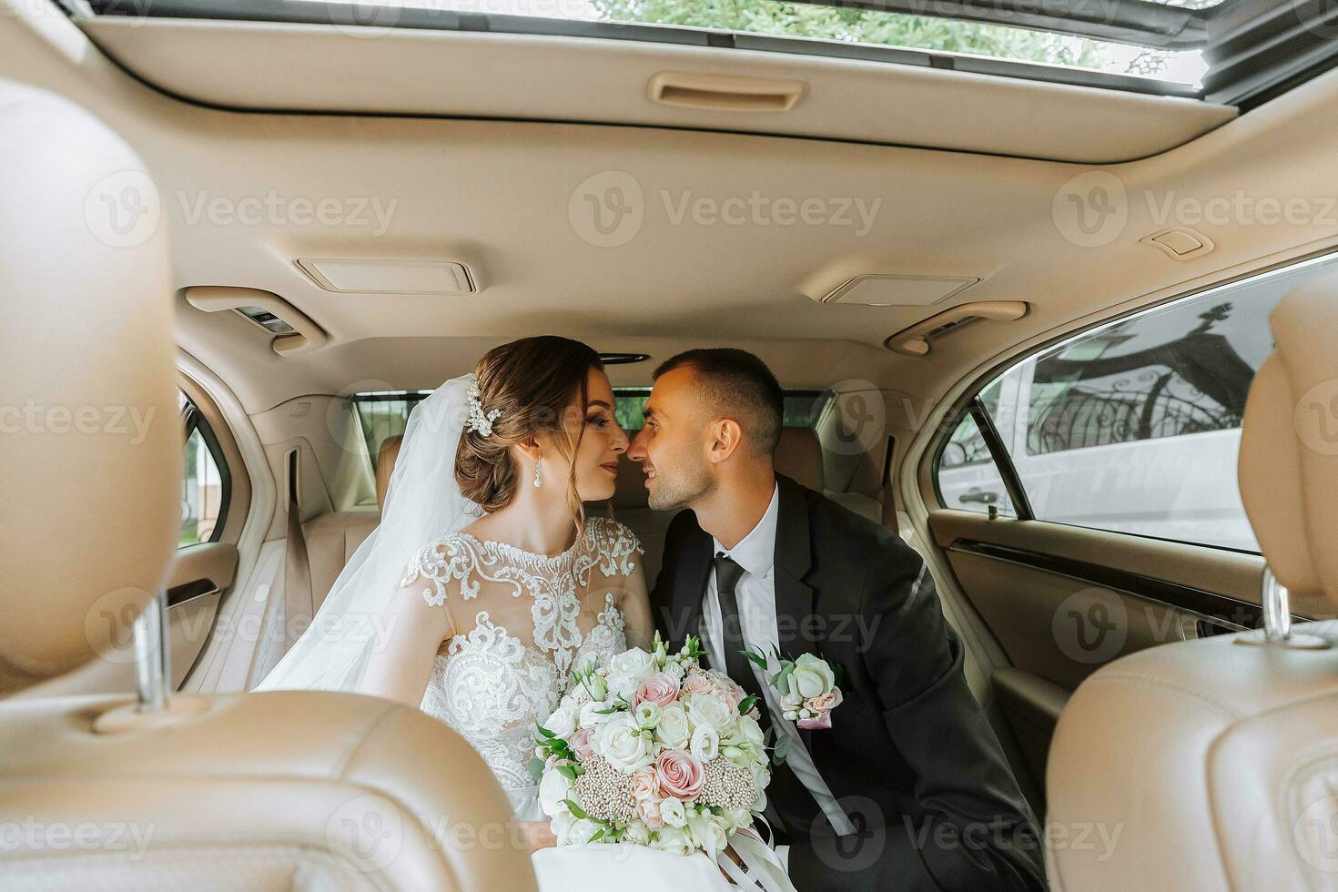 ung Lycklig brud och brudgum är fröjd efter de bröllop ceremoni i deras bil foto