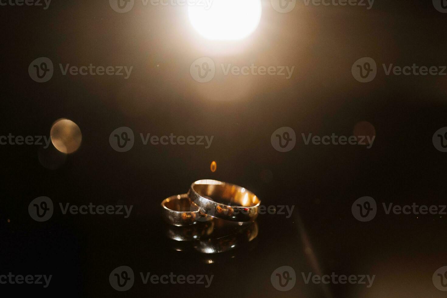 Tillbehör för de brudgummens bröllop dag. guld ringar på en mörk bakgrund med bakgrundsbelysning. herr- mode foto