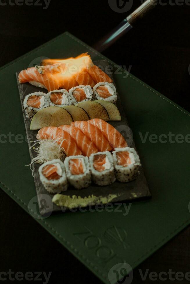 sushi rulla med lax och grädde ost på en svart bakgrund. foto