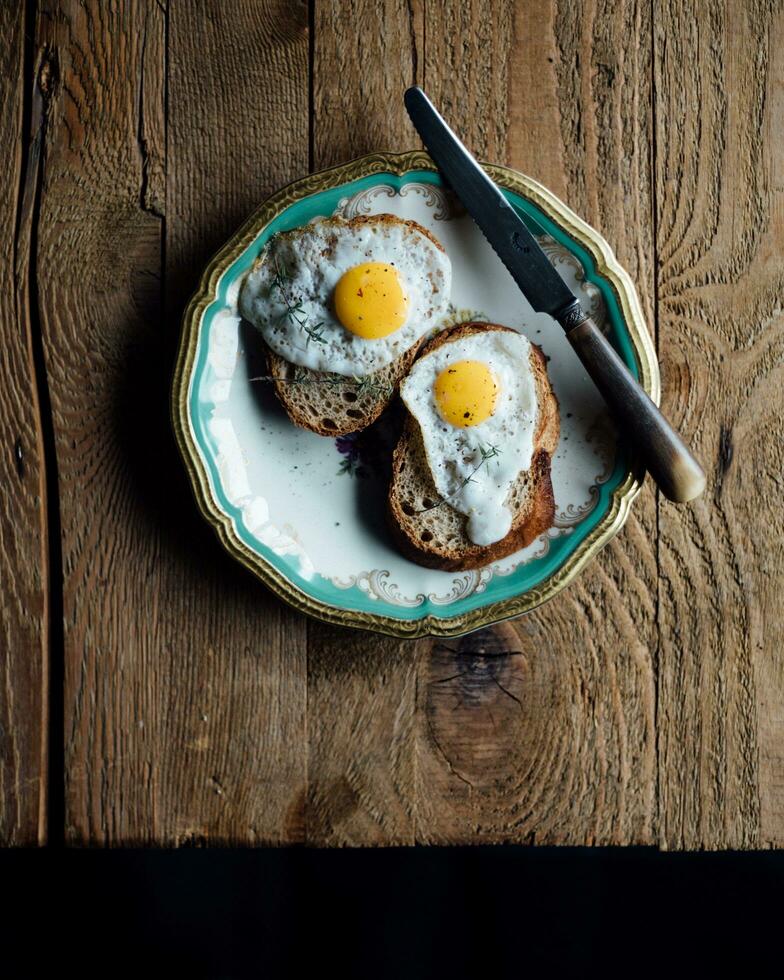 friterad ägg på rostat bröd för frukost. mörk rustik stil. foto