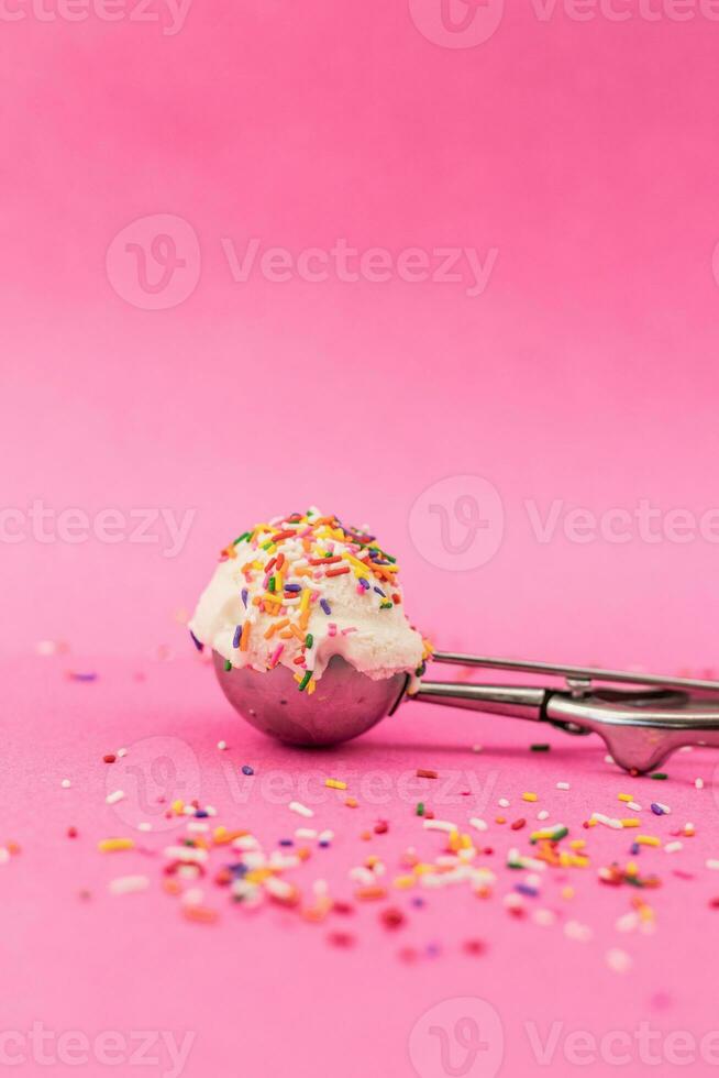 vanilj is grädde skopa med färgrik strössel på rosa bakgrund. foto