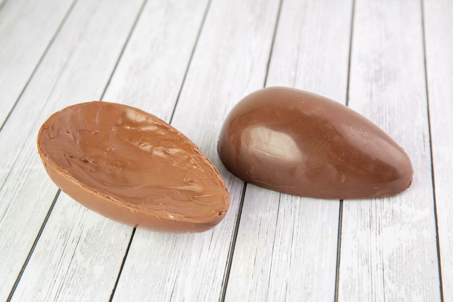 choklad godis i skål på vit trä- tabell, närbild foto