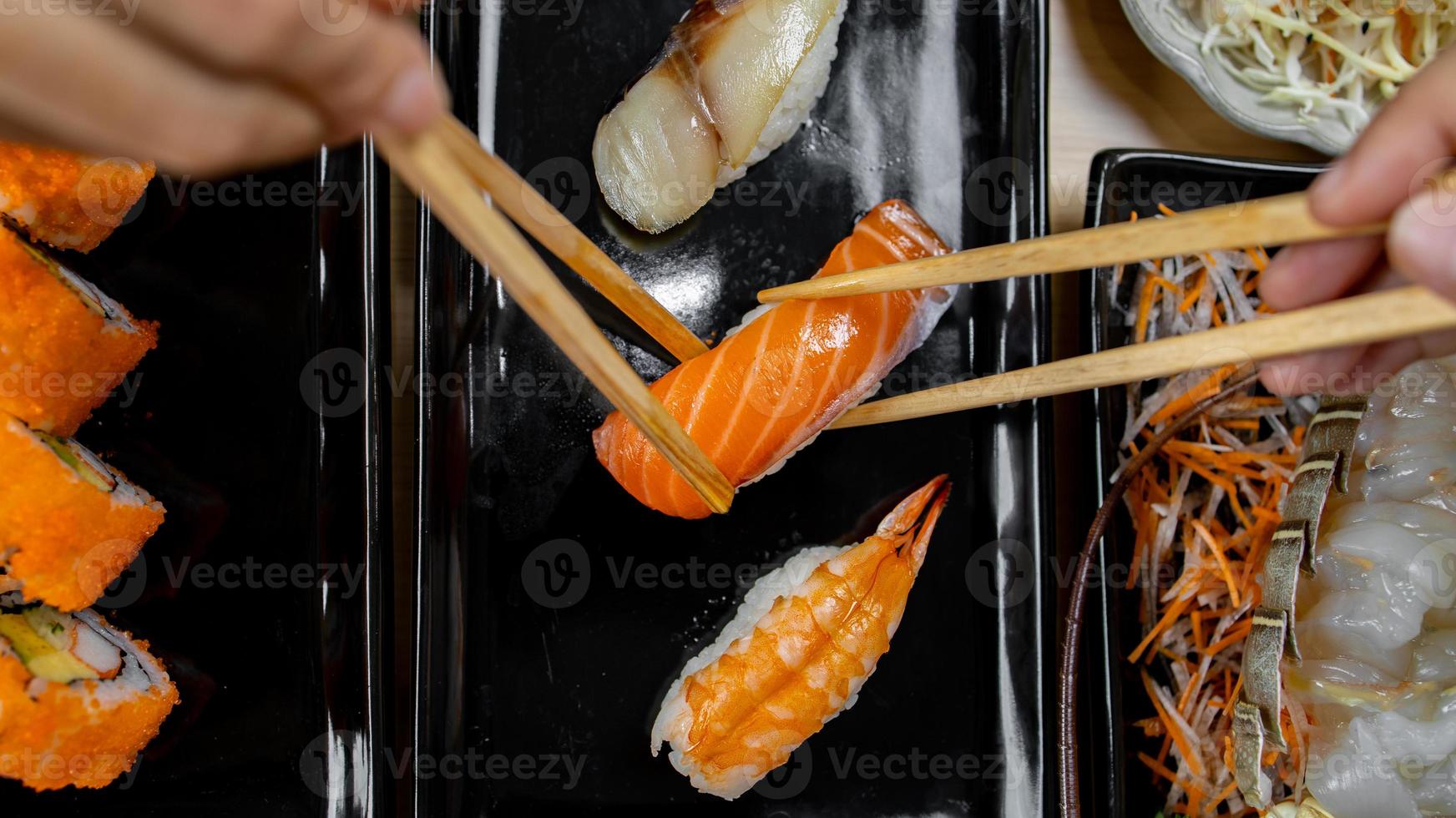 hand som håller ätpinne för att äta japansk mat foto