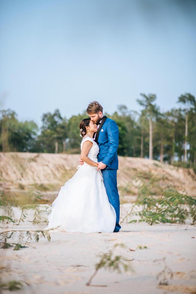 asiatisk brud och kaukasisk brudgum har romantisk tid och är lyckliga tillsammans foto