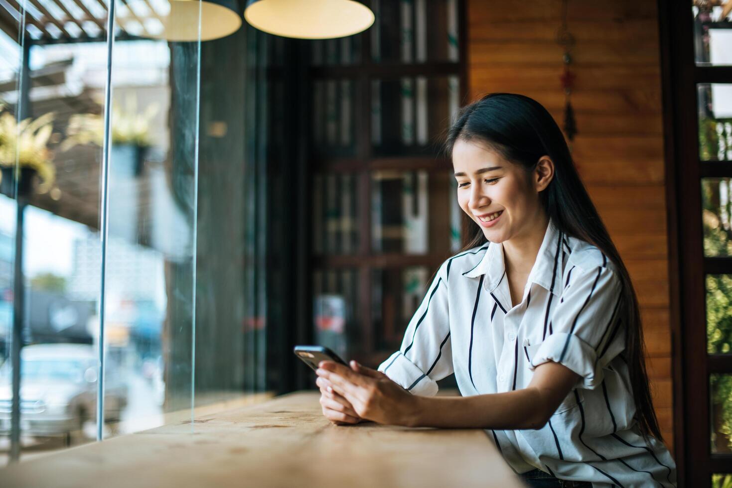 vacker kvinna som läser tidningen i caféet foto