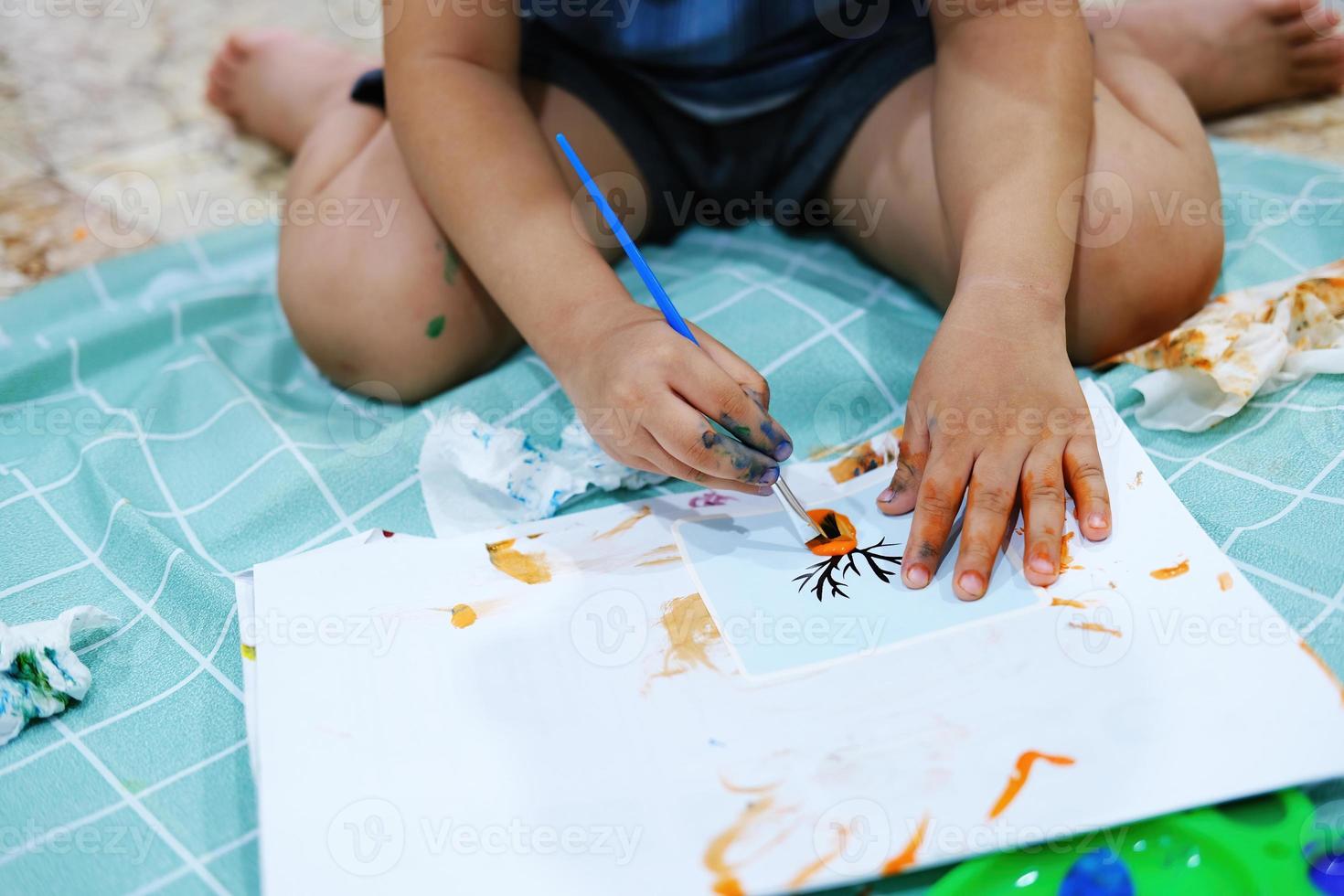 fokusera på händerna på papper. barn använder penslar för att måla akvareller på papper för att skapa sin fantasi och förbättra sina inlärningskunskaper. foto