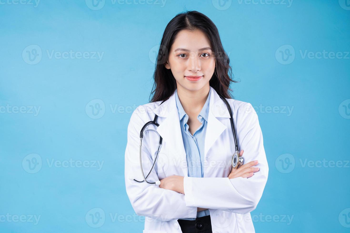 porträtt av ung kvinnlig läkare, isolerad på blå bakgrund foto