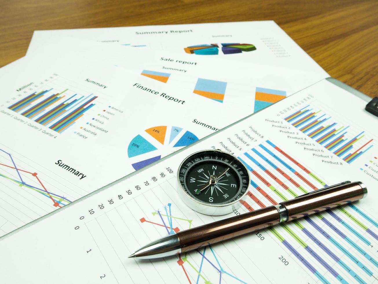 affärsrapportdiagram och finansiell grafanalys med penna och kompass på bordet foto