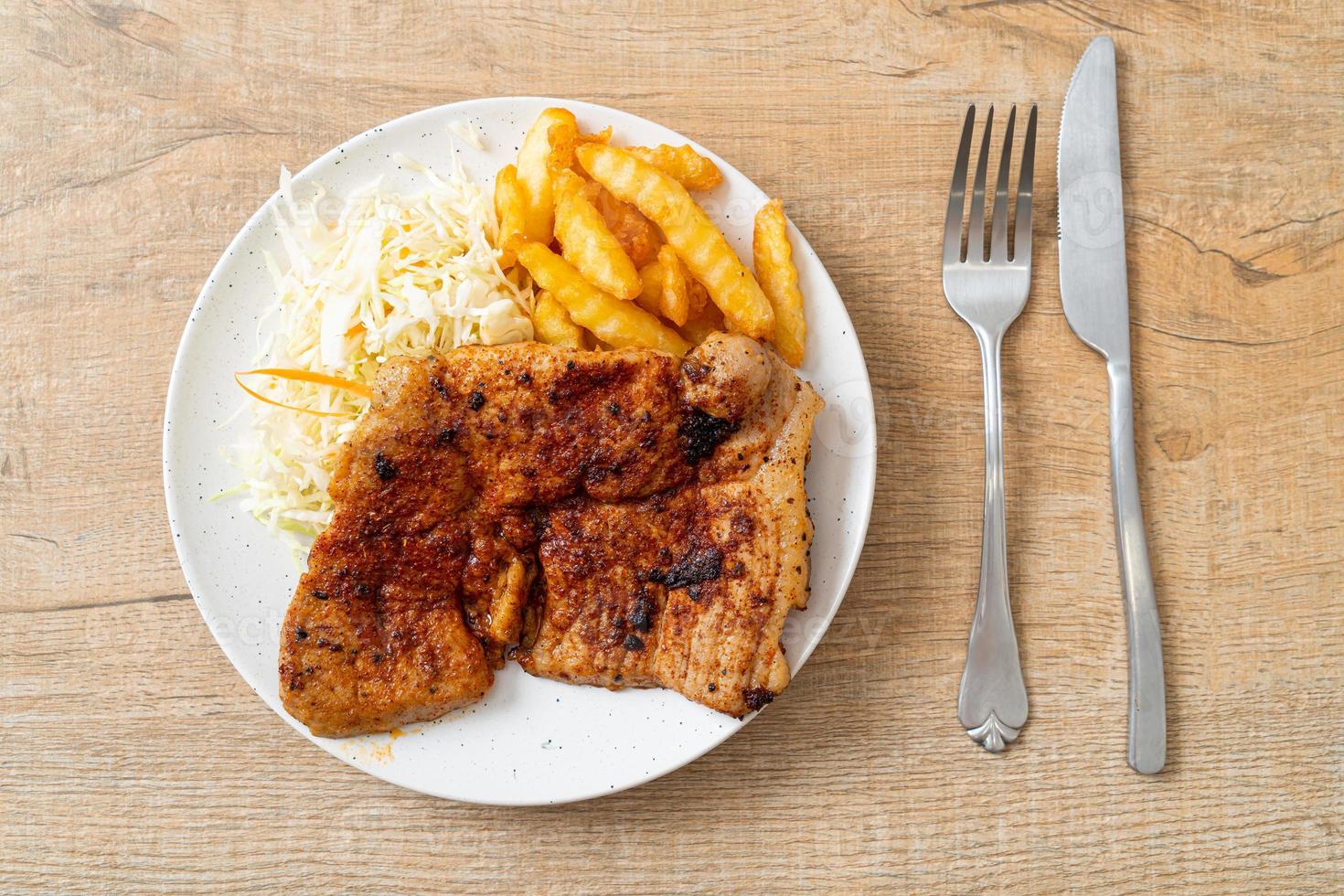 grillad kryddig grillfläskstek med pommes frites foto