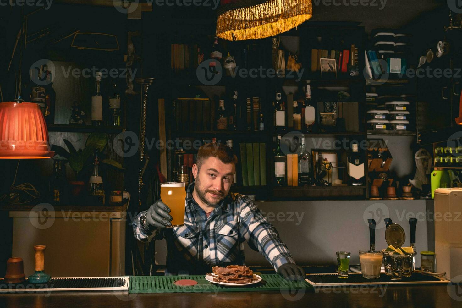 vänlig leende bartenderinnehav ut glas av ofiltrerad öl i pub foto