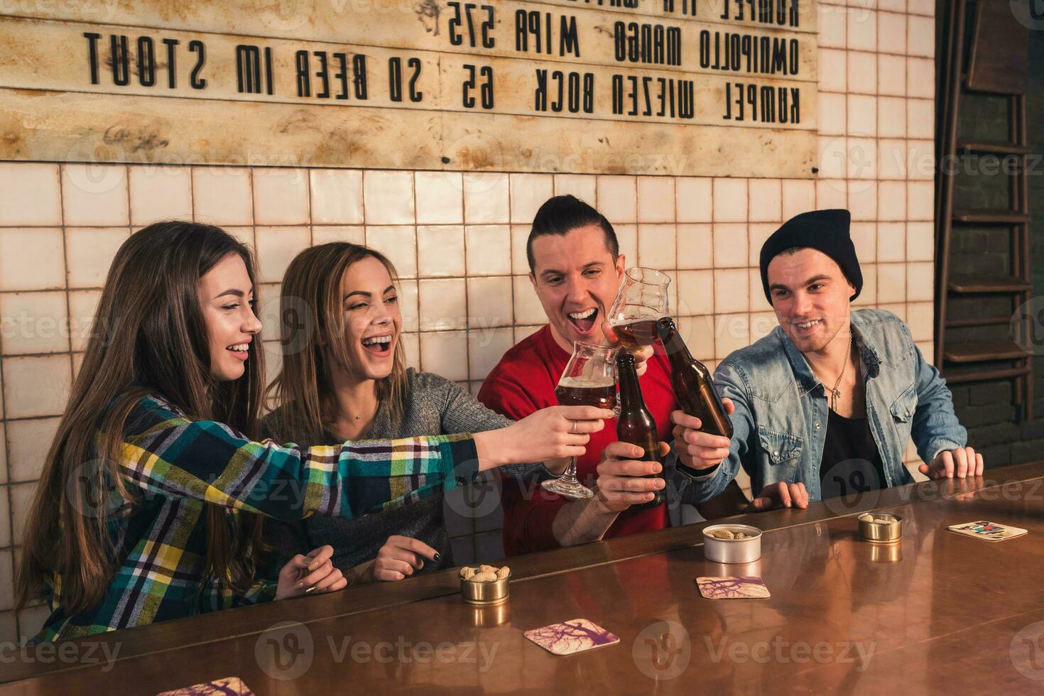 tittar på TV i pub. Lycklig ung vänner är glädjande för team ett foto