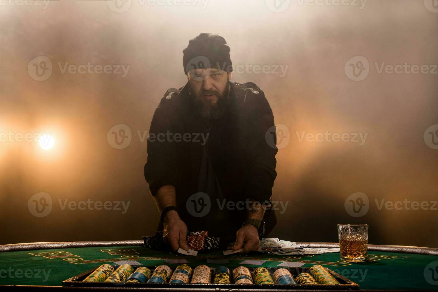 manlig spelare spelar poker, rök mörk Färg intensitet. foto