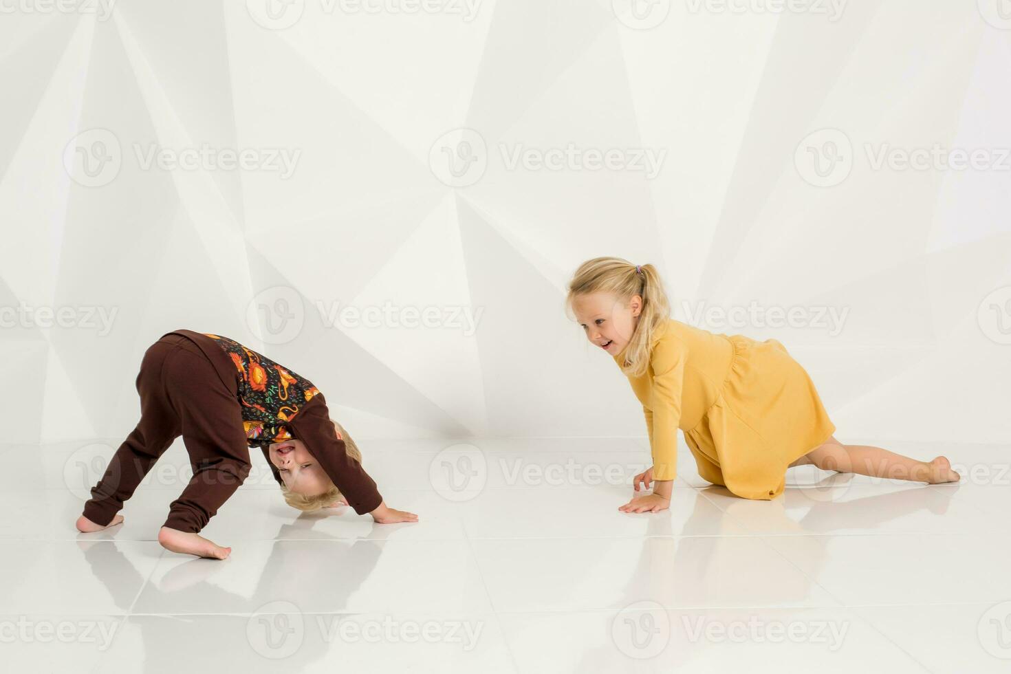 bror och syster spelar och leende i en vit studio foto