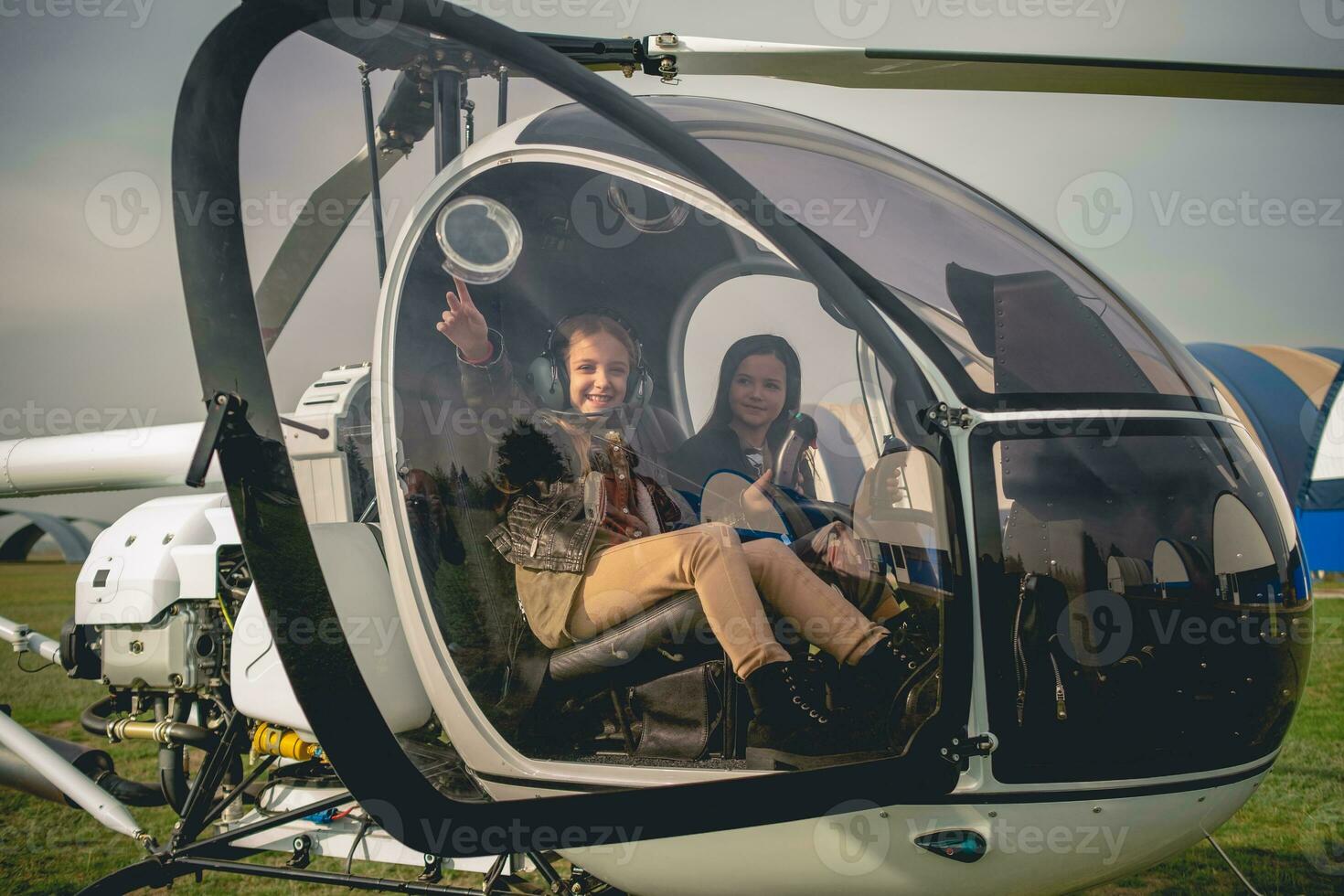 glad mellan flicka pekande till himmel från helikopter cockpit foto