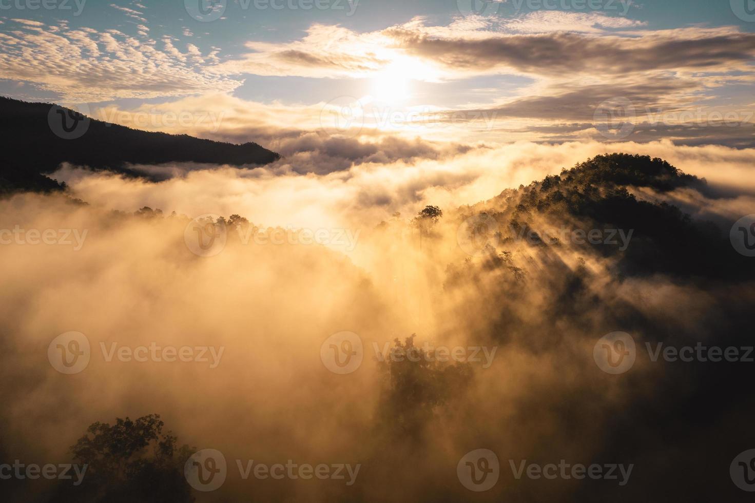 solen går upp i dimman och bergen på morgonen foto