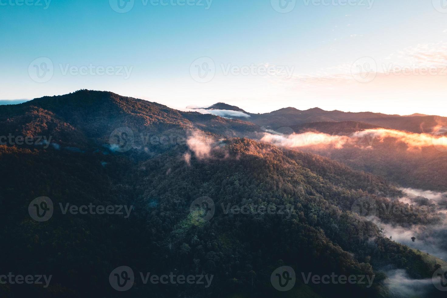 solen går upp i dimman och bergen på morgonen foto
