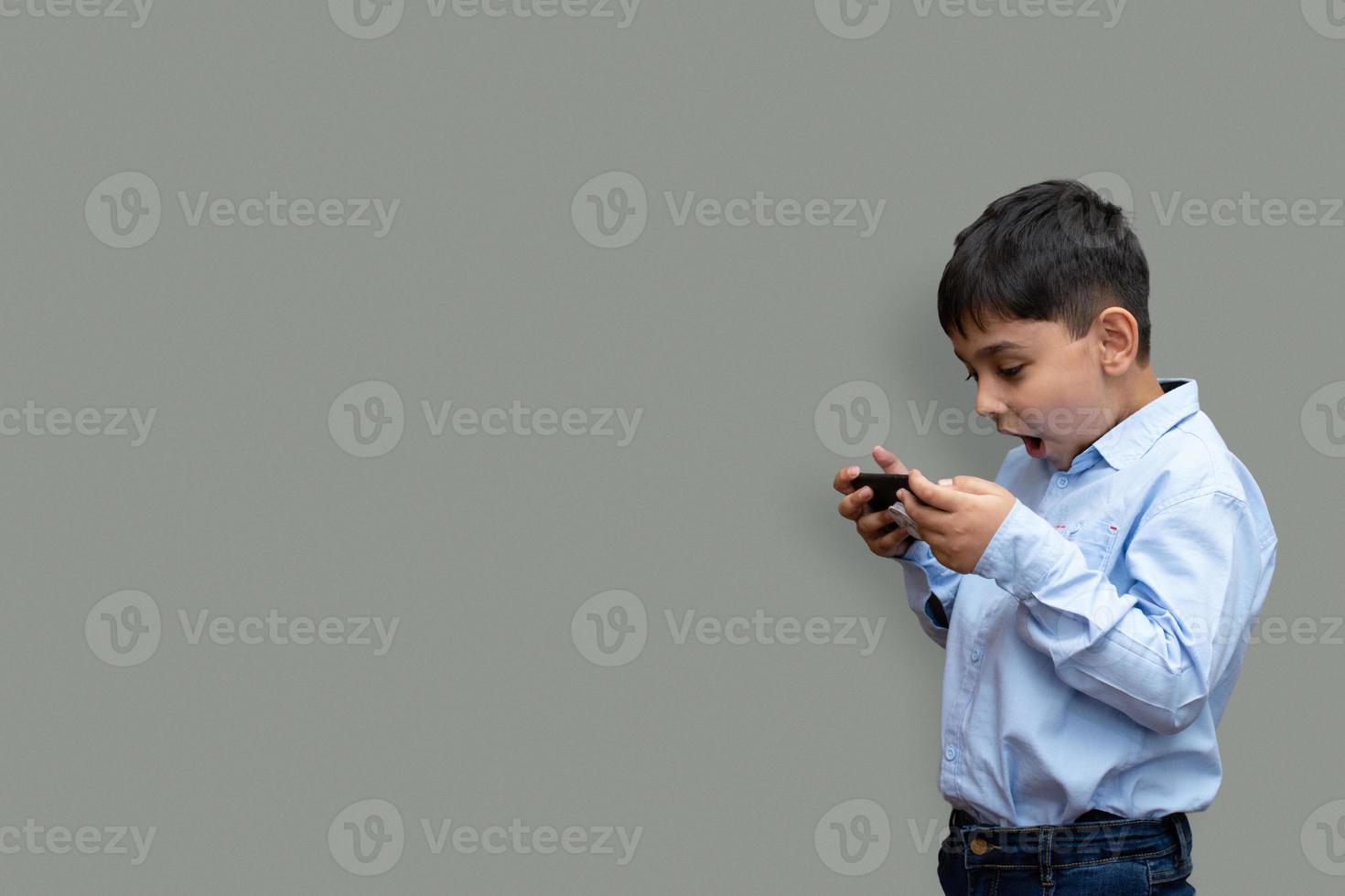 fritid, barn, teknik och människor koncept - leende pojke med smartphone eller spela spel hemma kopia utrymme foto