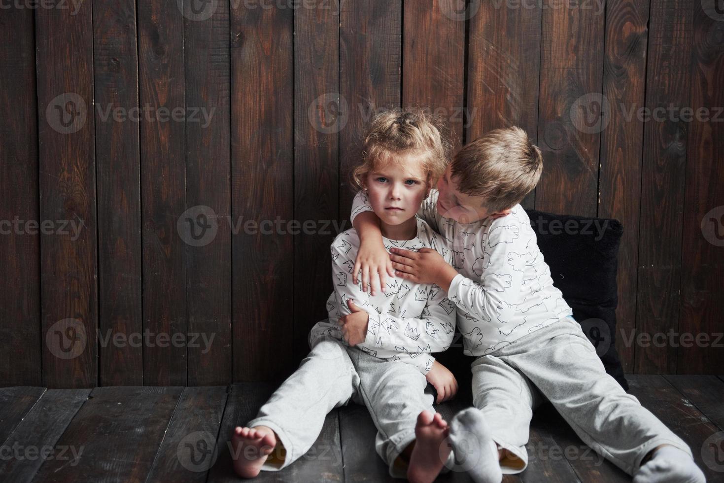 två barn, bror och syster i pyjamas leker tillsammans foto