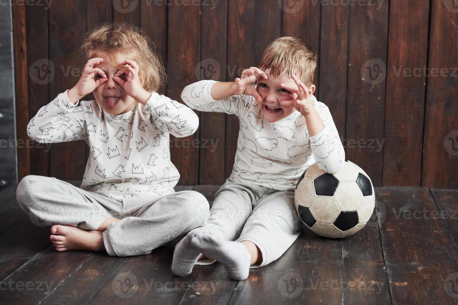 två barn, bror och syster i pyjamas leker tillsammans foto