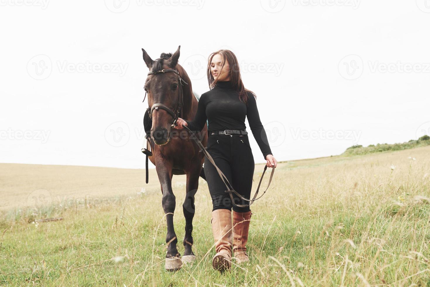 en ung flicka står nära sitt berg. hon älskar djuren och spenderar med glädje sin tid i deras miljö foto