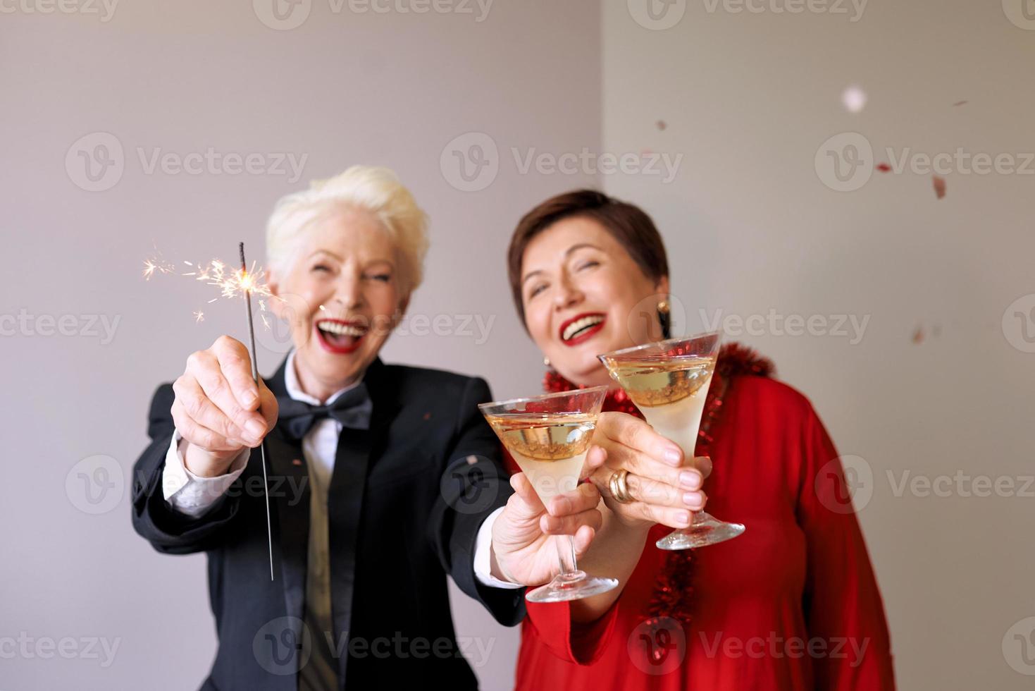två vackra snygga mogna äldre kvinnor som firar nytt år. kul, fest, stil, firande koncept foto